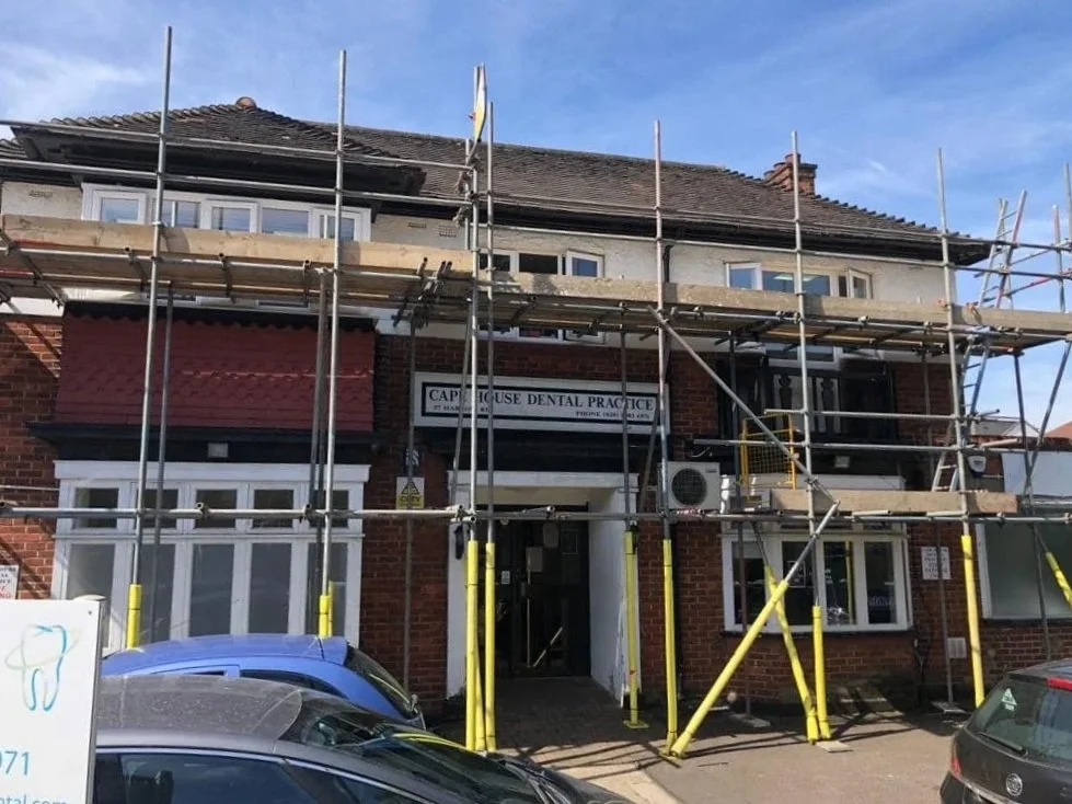 A two-story brick building in north london under renovation by K G Croft, with scaffolding around the front and a sign reading 'Cape House Dental Practice' above the entrance.