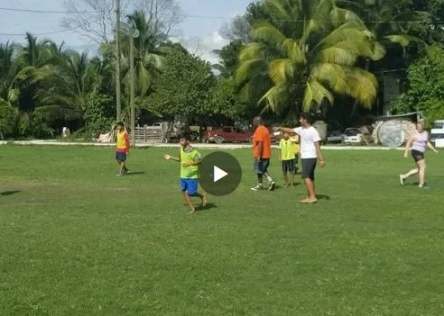 Group playing Soccer (football) with a group of local kids, in Belize 