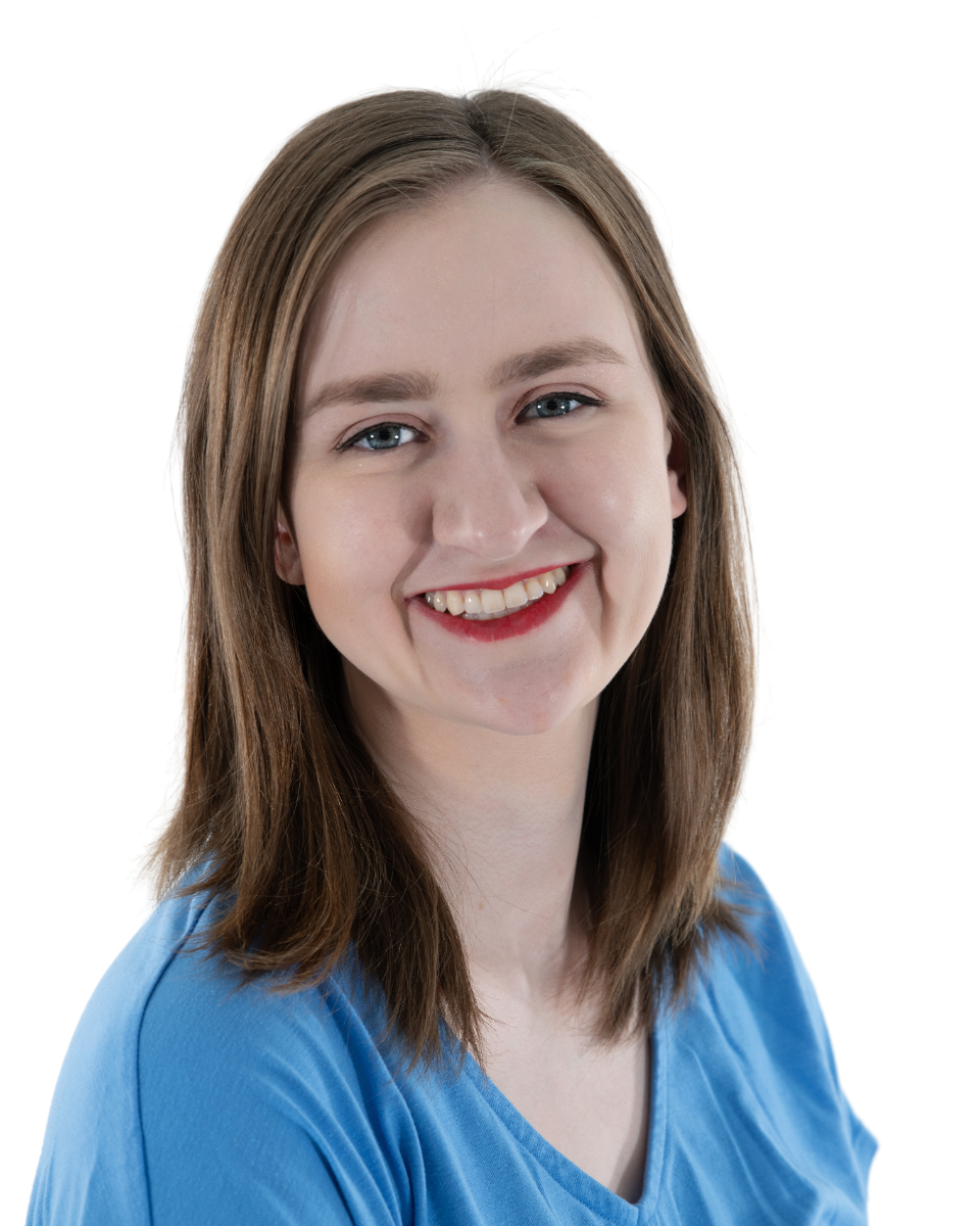 A young woman with shoulder-length brown hair, blue eyes, wearing a blue shirt, smiling against a white background.