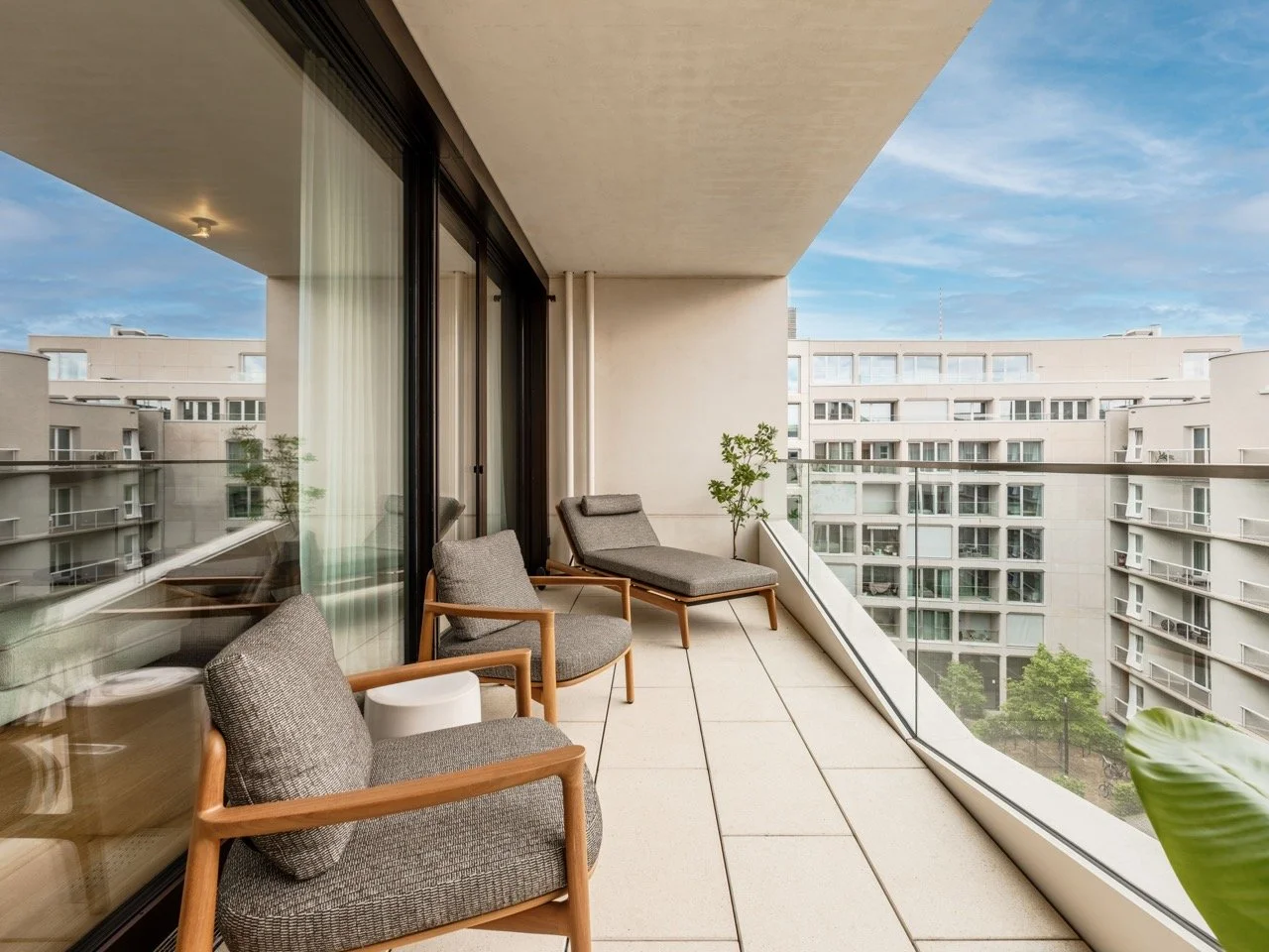 Balkon mit Sitzmöbeln und Blick auf andere Wohngebäude