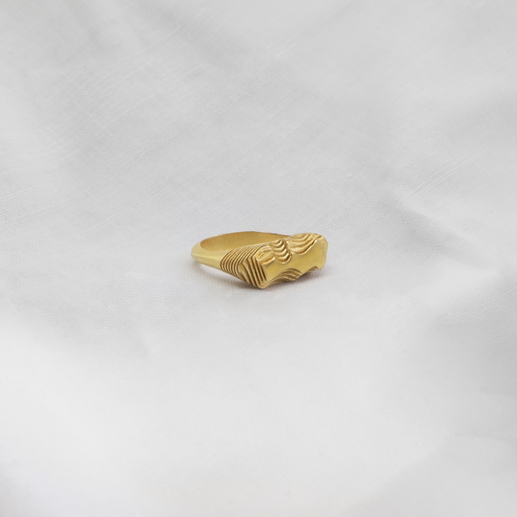 Handmade gold ring with layered topographic texture inspired by geological landscape formations, sculptural jewelry by Cadera Jewelry