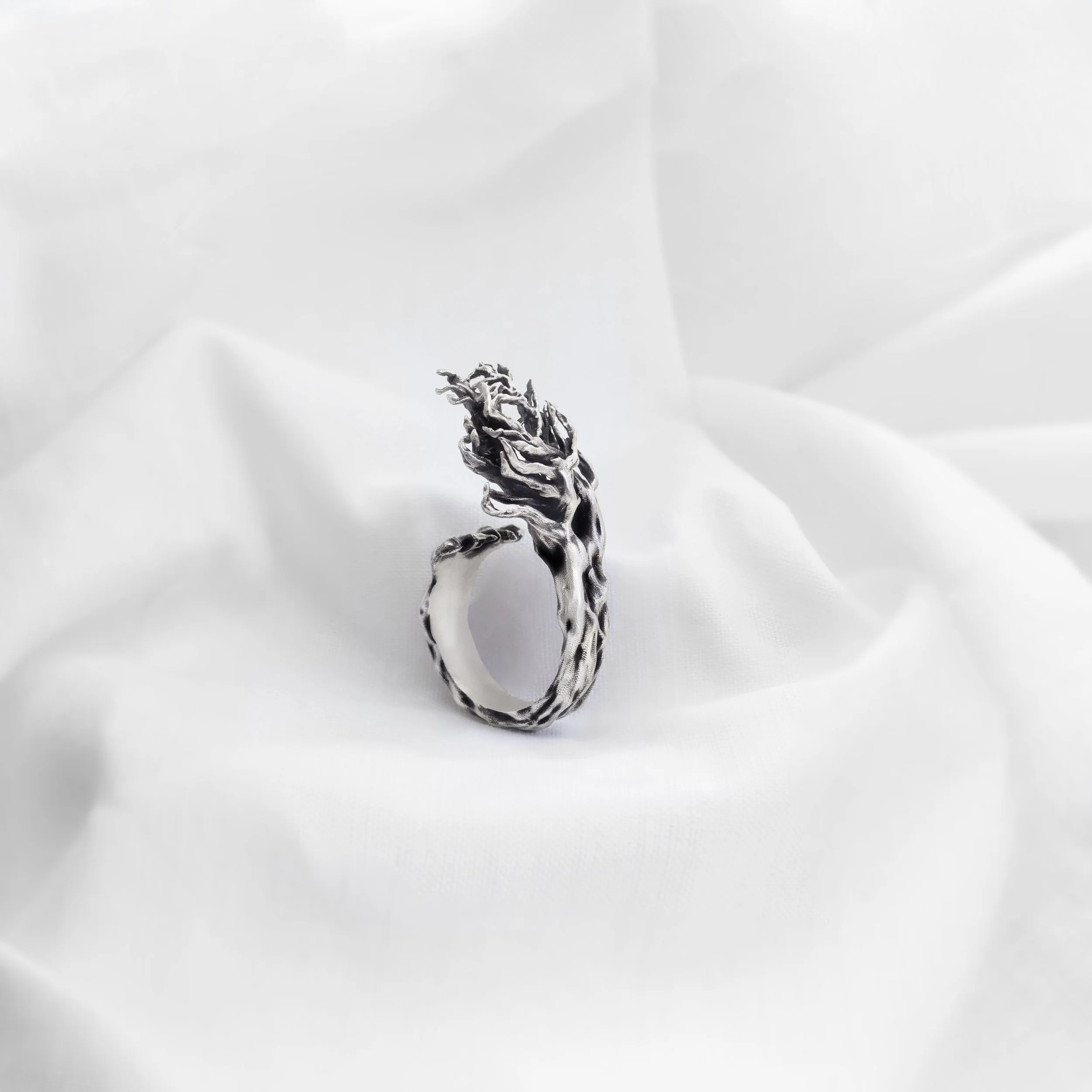 Handmade silver ring inspired by a wind-bent tree, sculptural organic design with flowing textured form by Cadera Jewelry