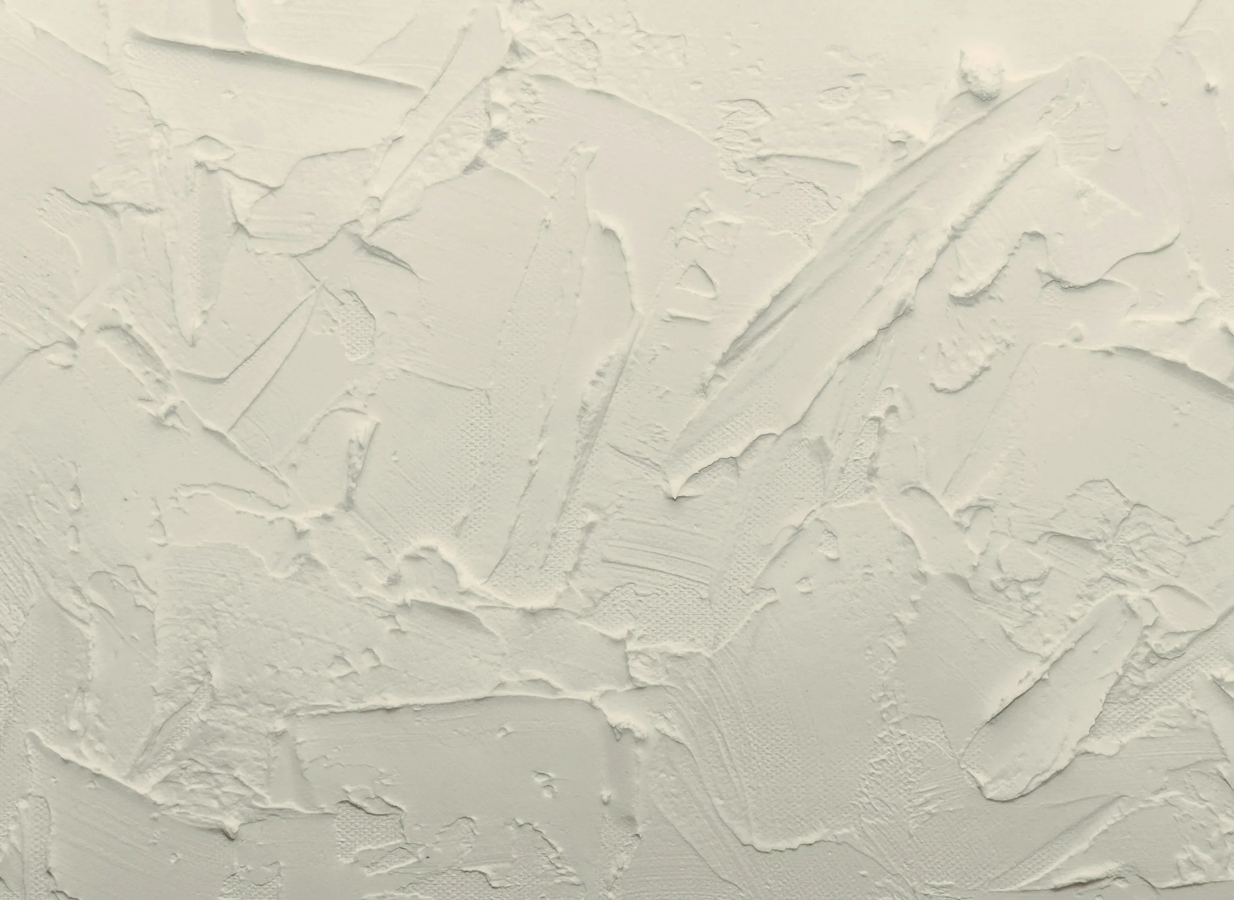 Close-up of a textured white wall surface with rough, uneven patterns and brush strokes.