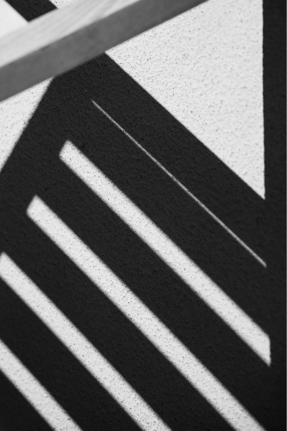 Close-up of a monochrome stencil art with geometric black and white stripes and diagonal lines.