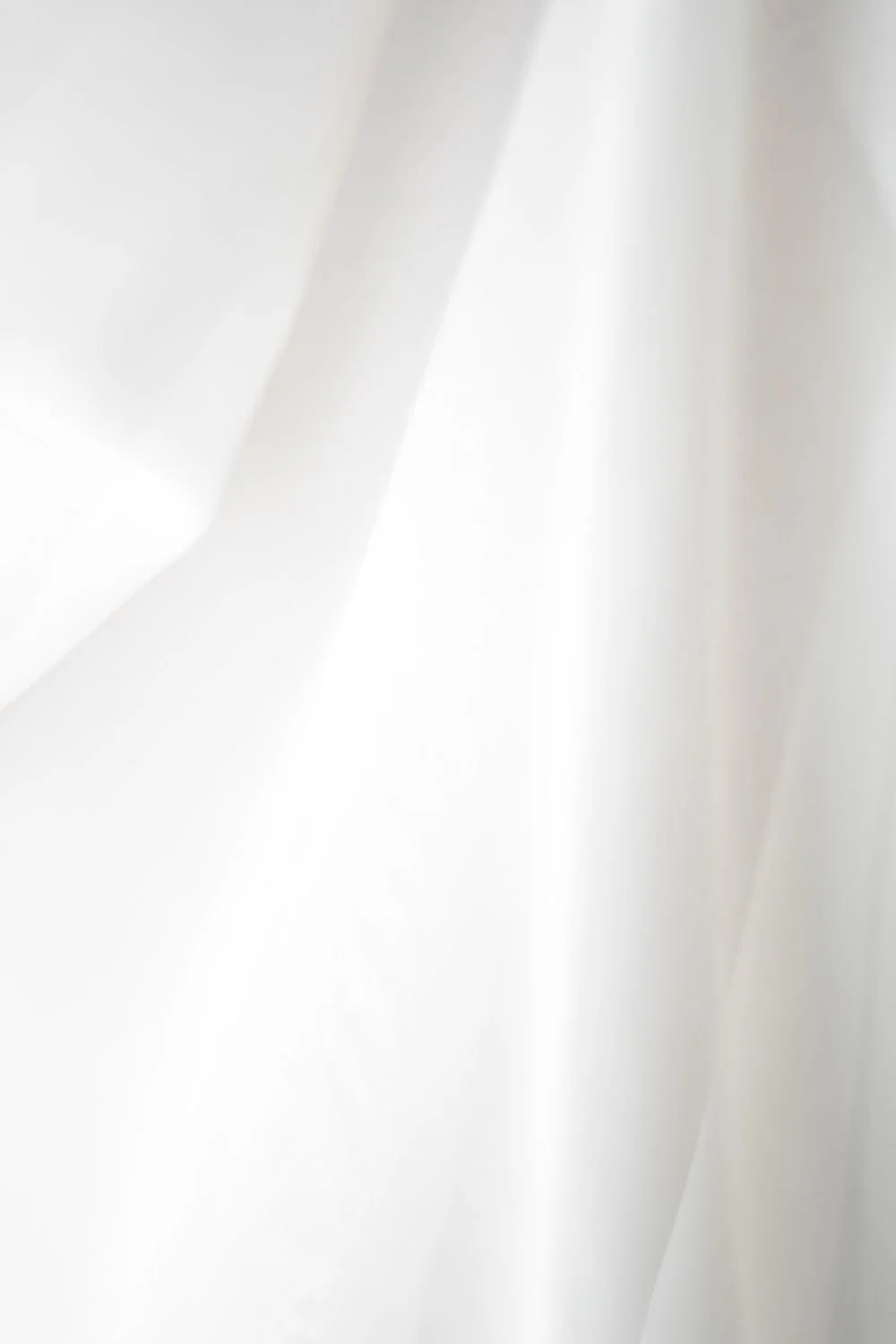 Abstract white light and shadow with soft folds and textures.