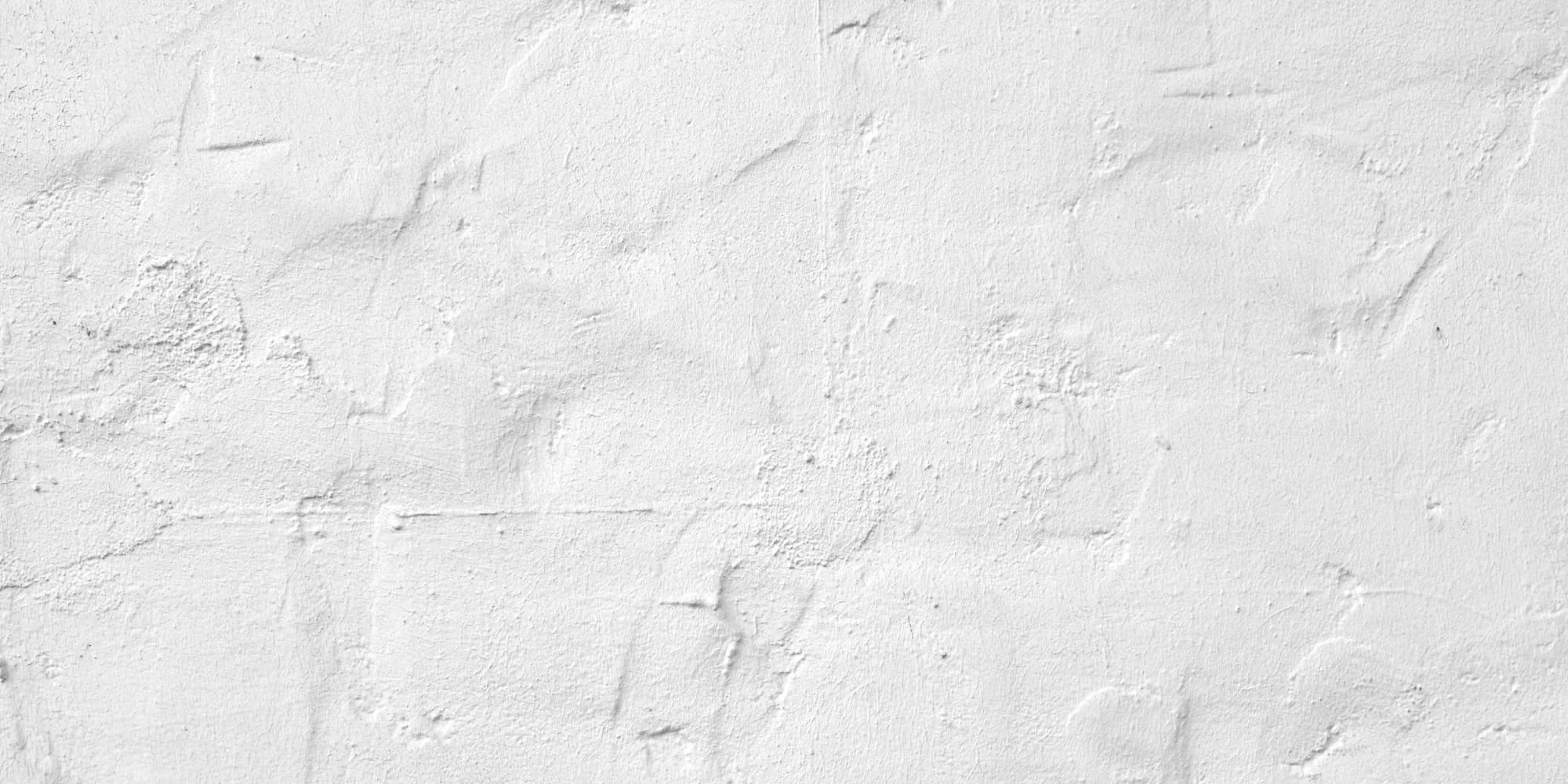 White textured wall with rough surface and various indentations.
