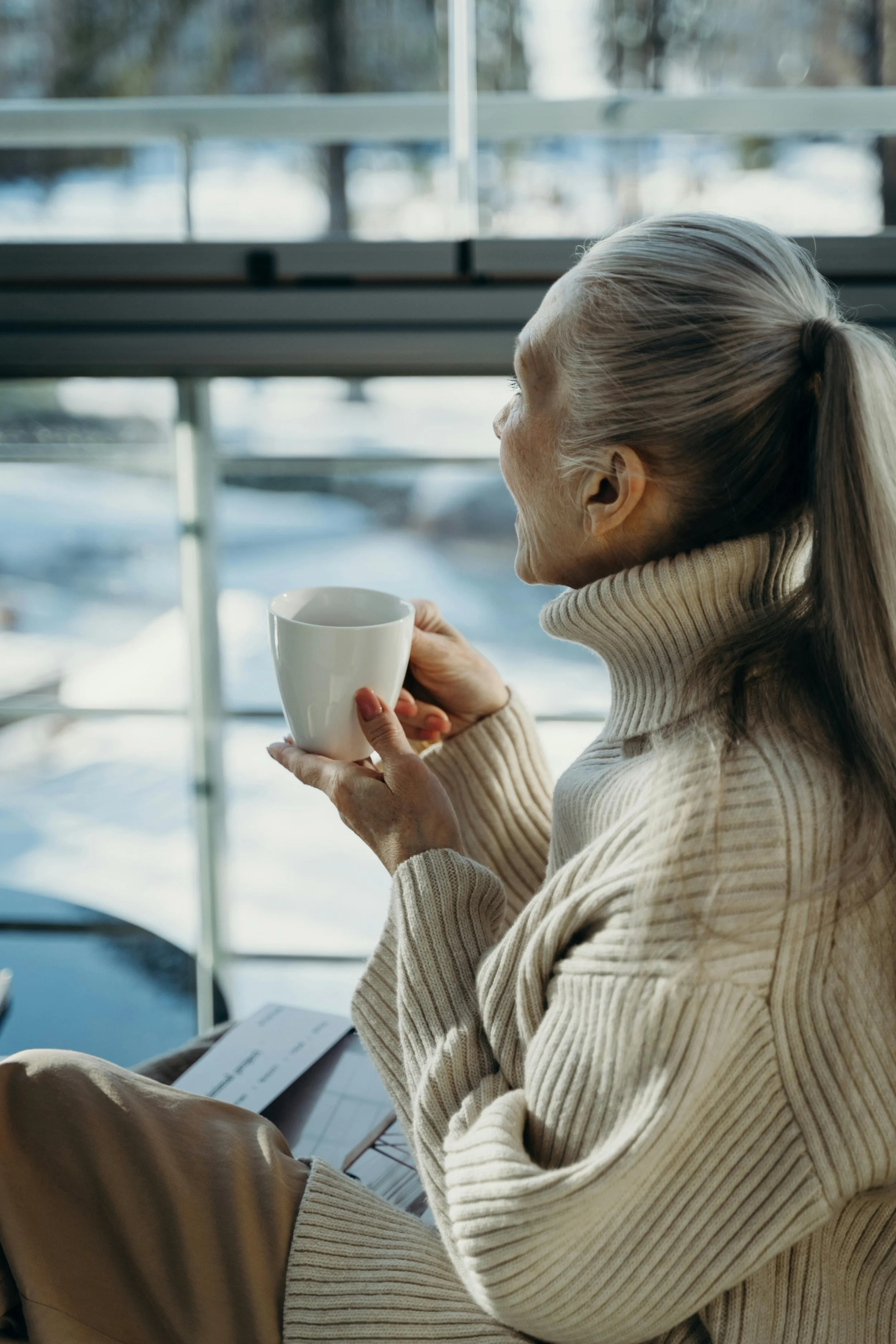 Housing Adaptation. Woman sits with cup pondering how to make her home more accessible.