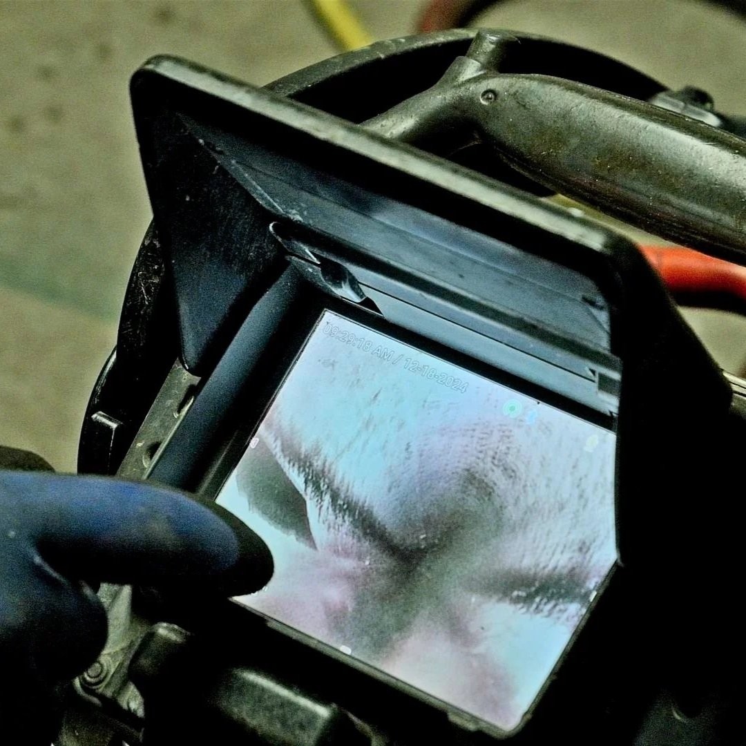 Close-up of sewer camera screen showing grease buildup inside pipe.