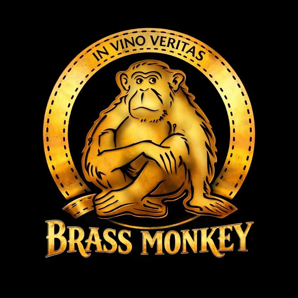 A golden brass monkey with a serious expression sitting with crossed arms inside a circular border. Above the monkey, the text reads "IN VINO VERITAS" and below in bold letters, "BRASS MONKEY" against a black background.