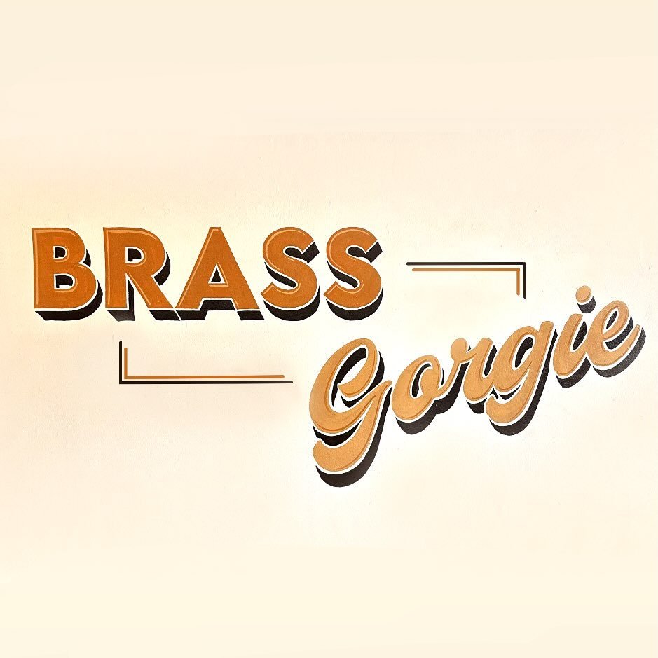 Text saying 'Brass Gorgie' with a beige background, 'Brass' in bold orange letters and 'Gorgie' in a script font with a shadow effect.