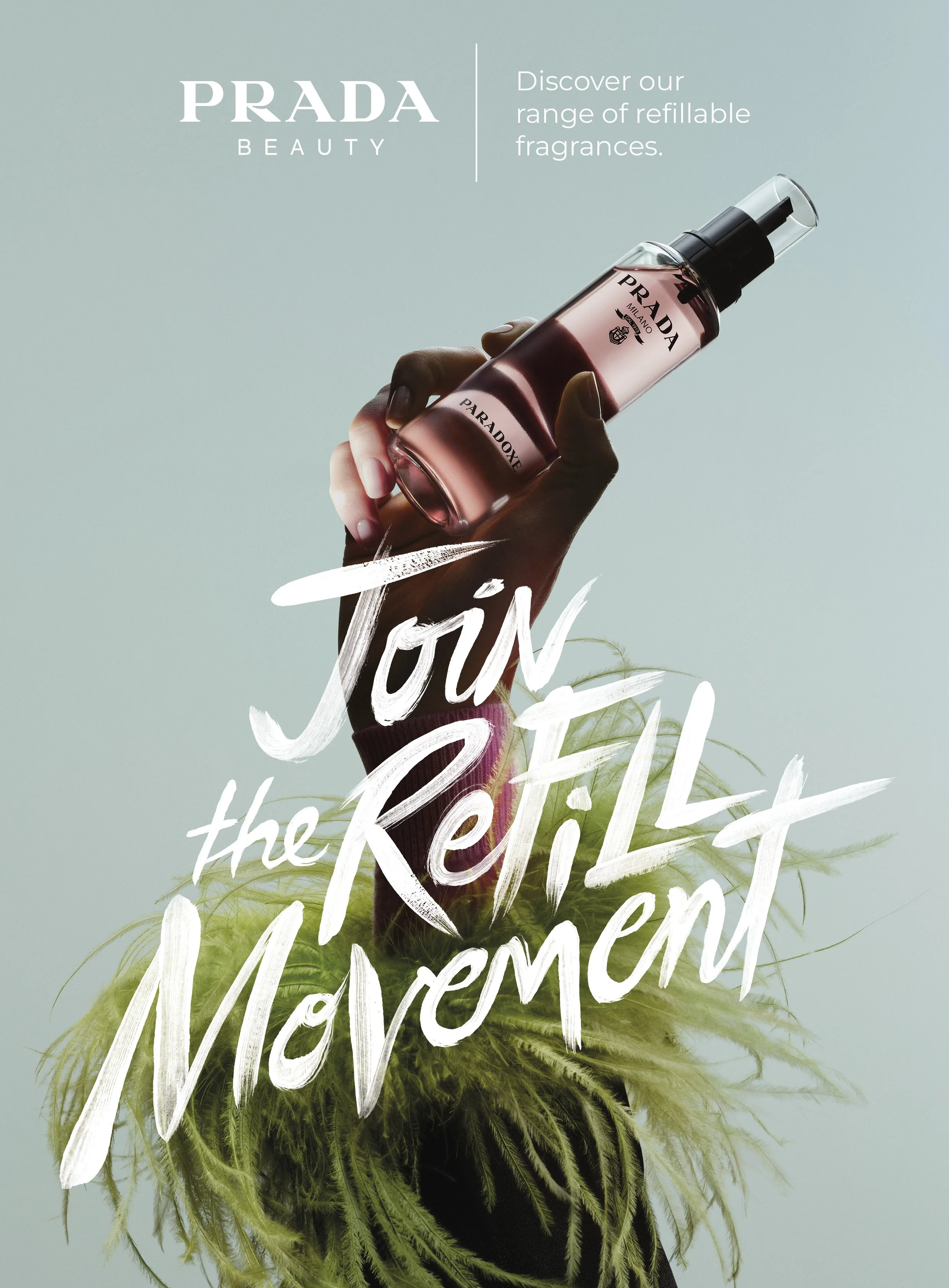 Publicité pour le parfum Prada Paradoxe, montrant une main tenant une bouteille de parfum à pulvérisation, avec un fond vert clair, des plantes vertes, et un texte en blanc "Join the Refill Movement".