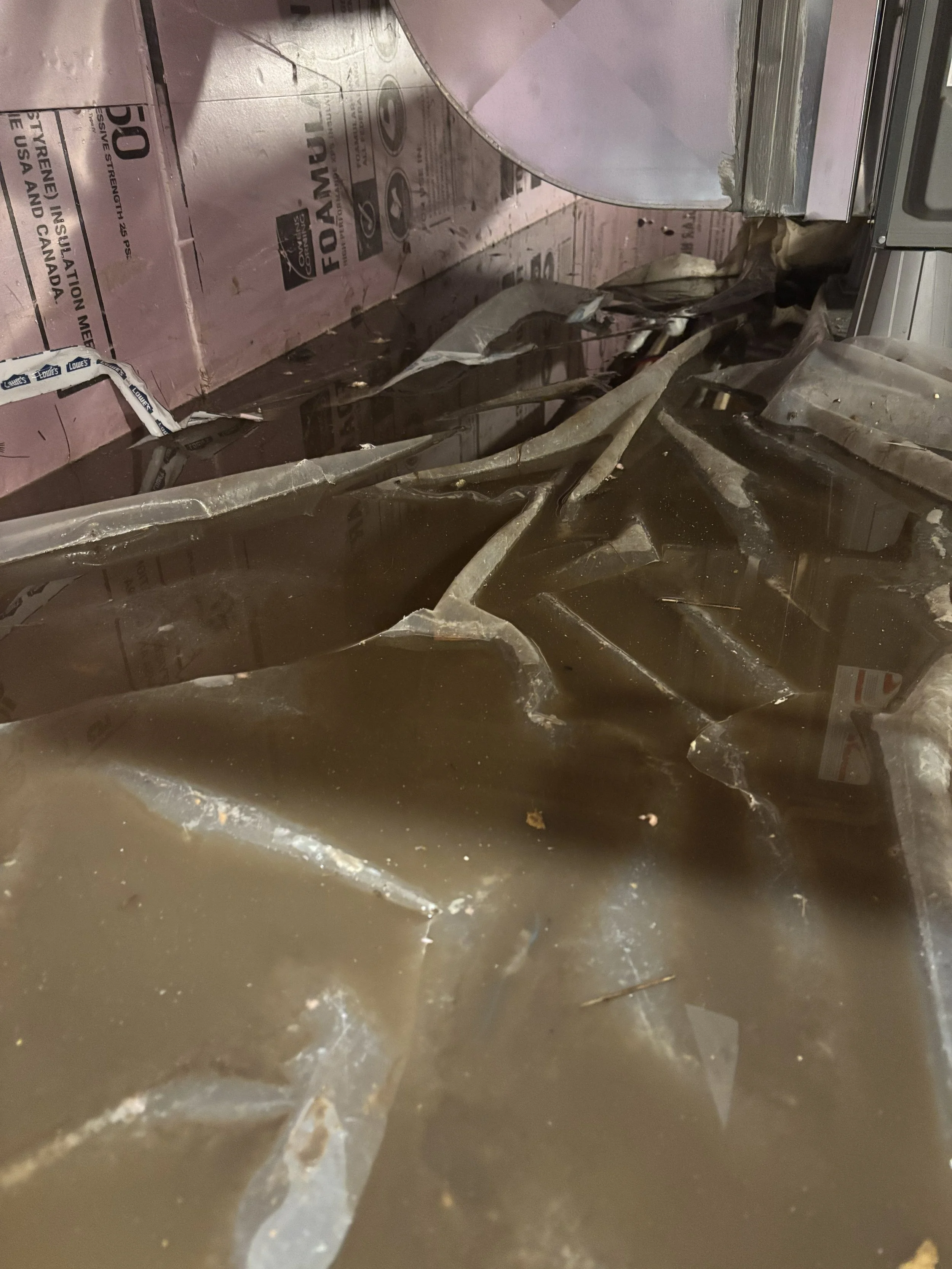 Broken glass and debris on the floor in a damaged kitchen or industrial area.