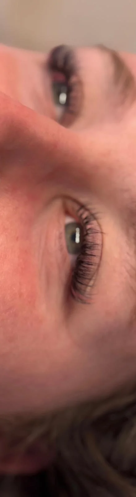Close-up of a person's face with detailed focus on their eyes and eyelashes.