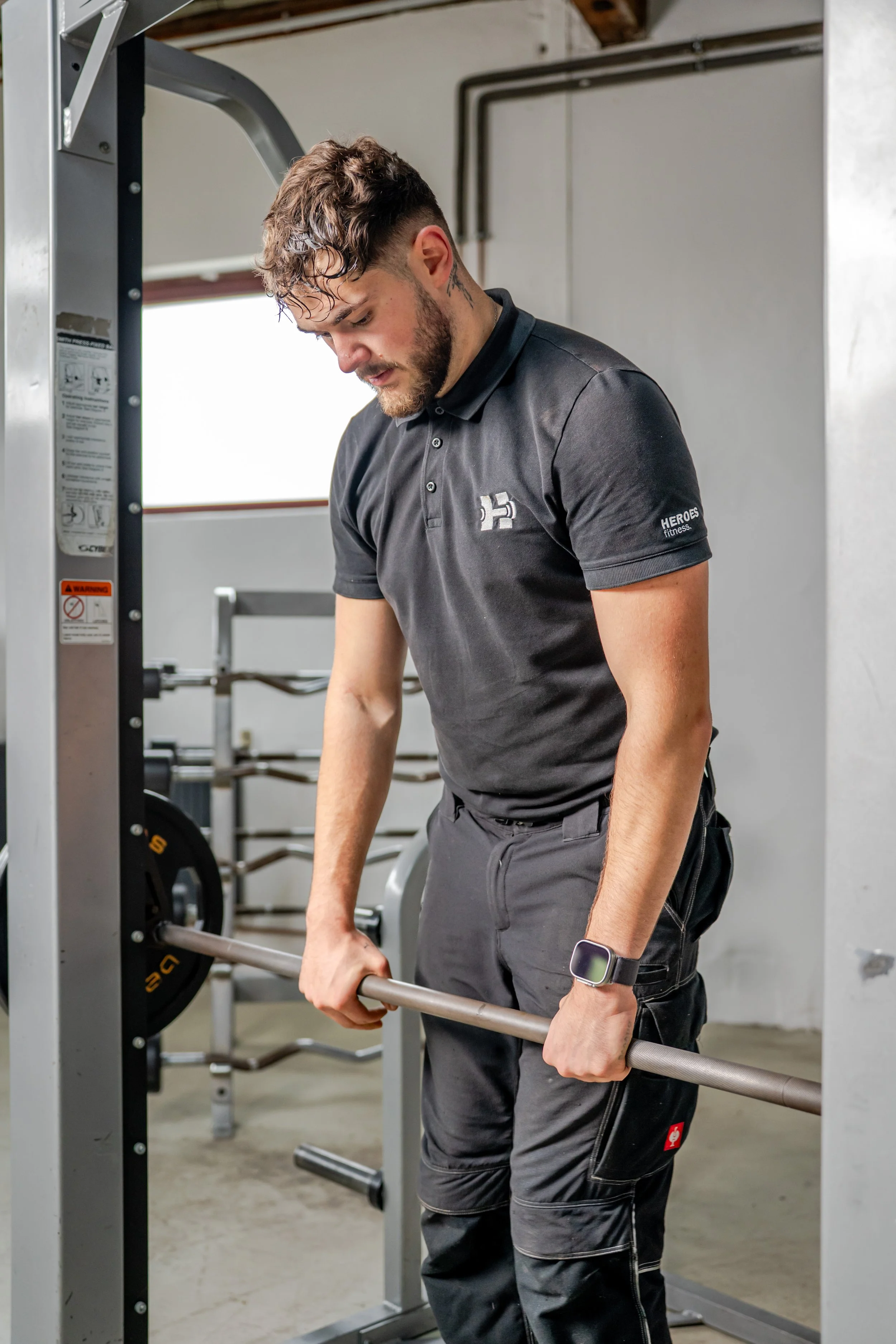 Mann bei Krafttraining mit Hantel im Fitnessstudio.