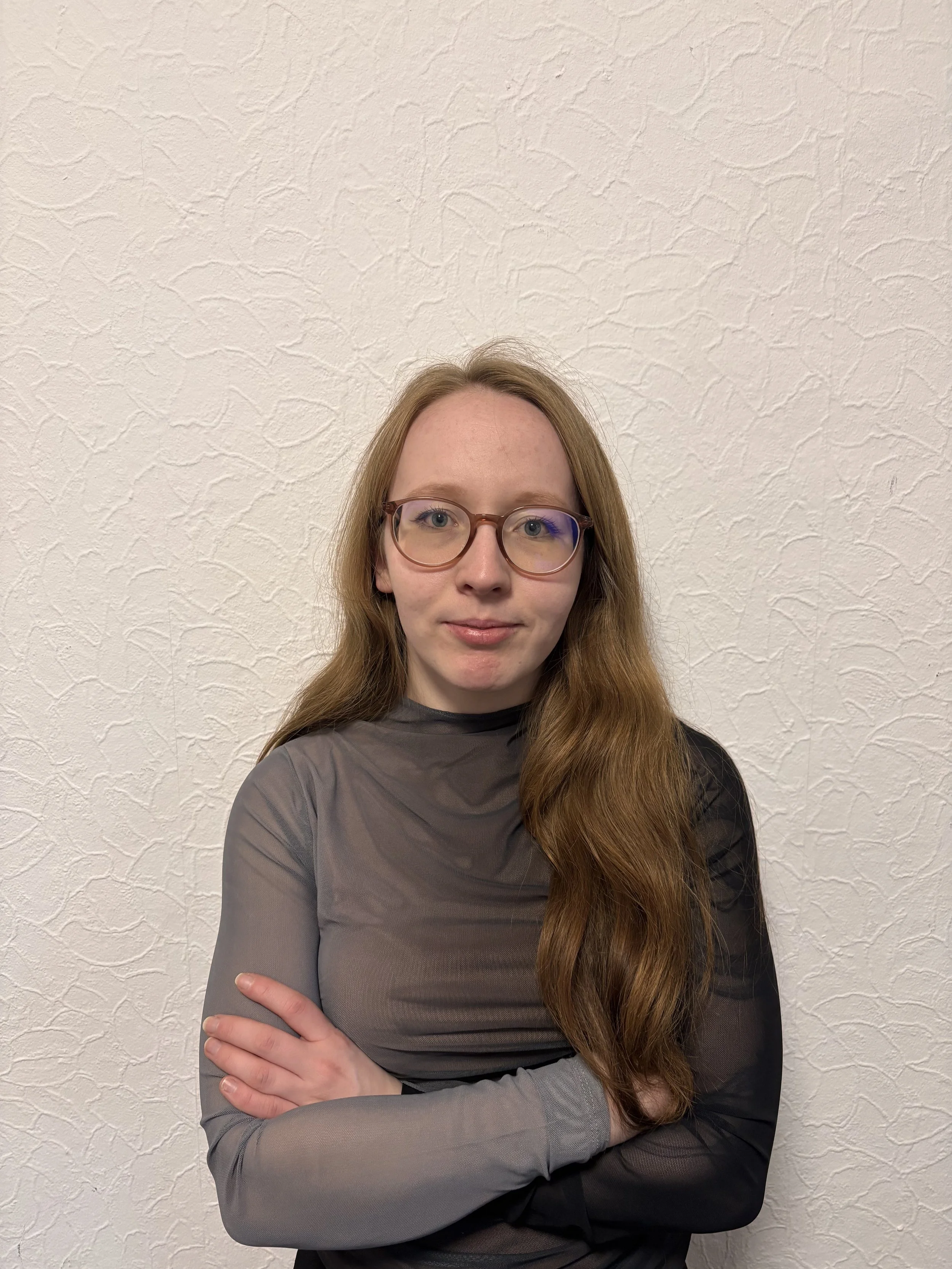 Junge Frau vor einer weißen Wand.