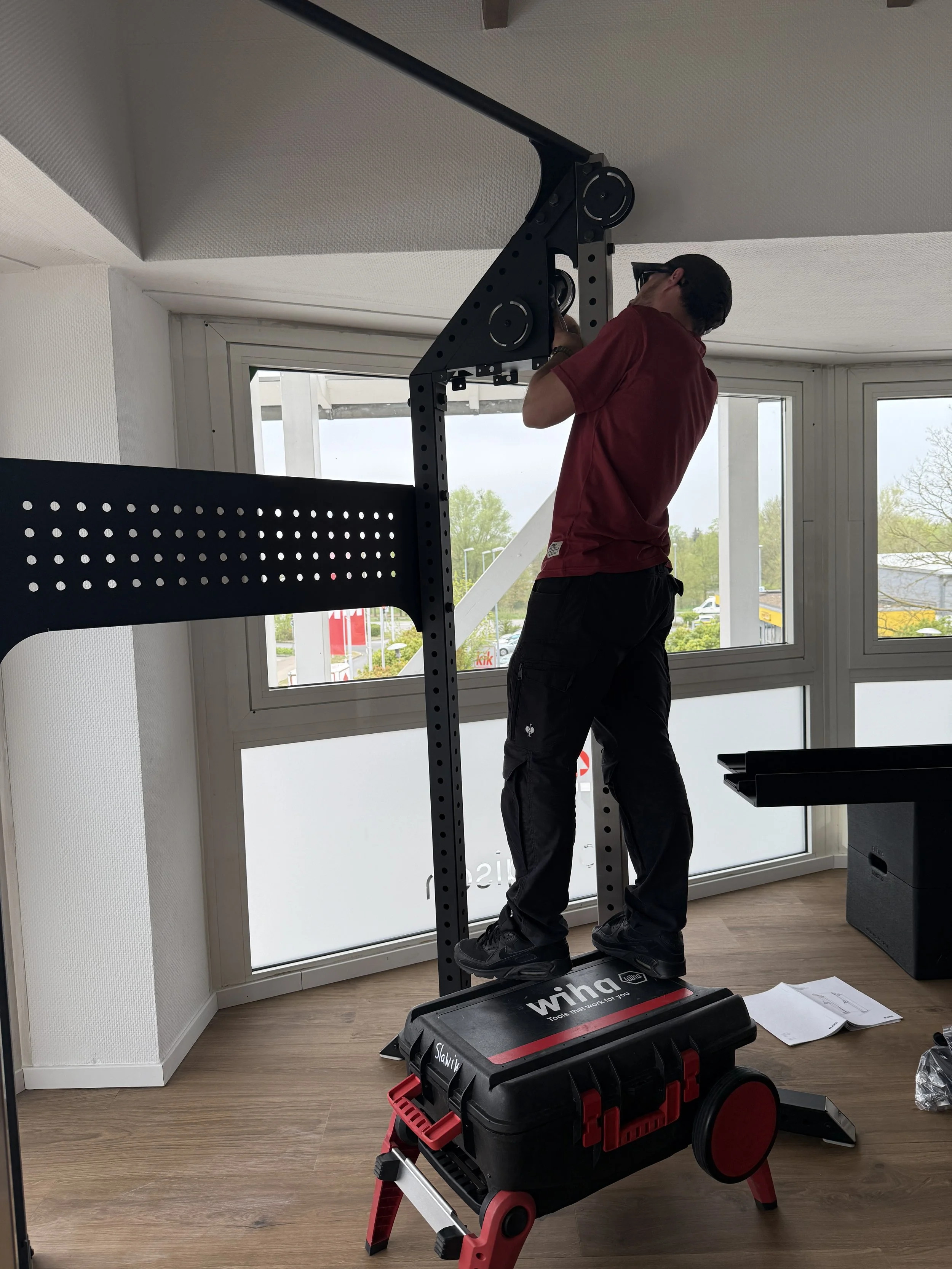 Handwerker schraubt an einem Fitnessgerät