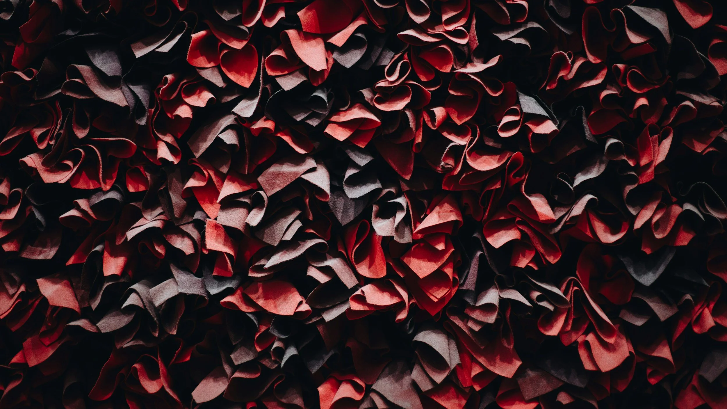 Close-up of a large pile of crumpled red and black paper.