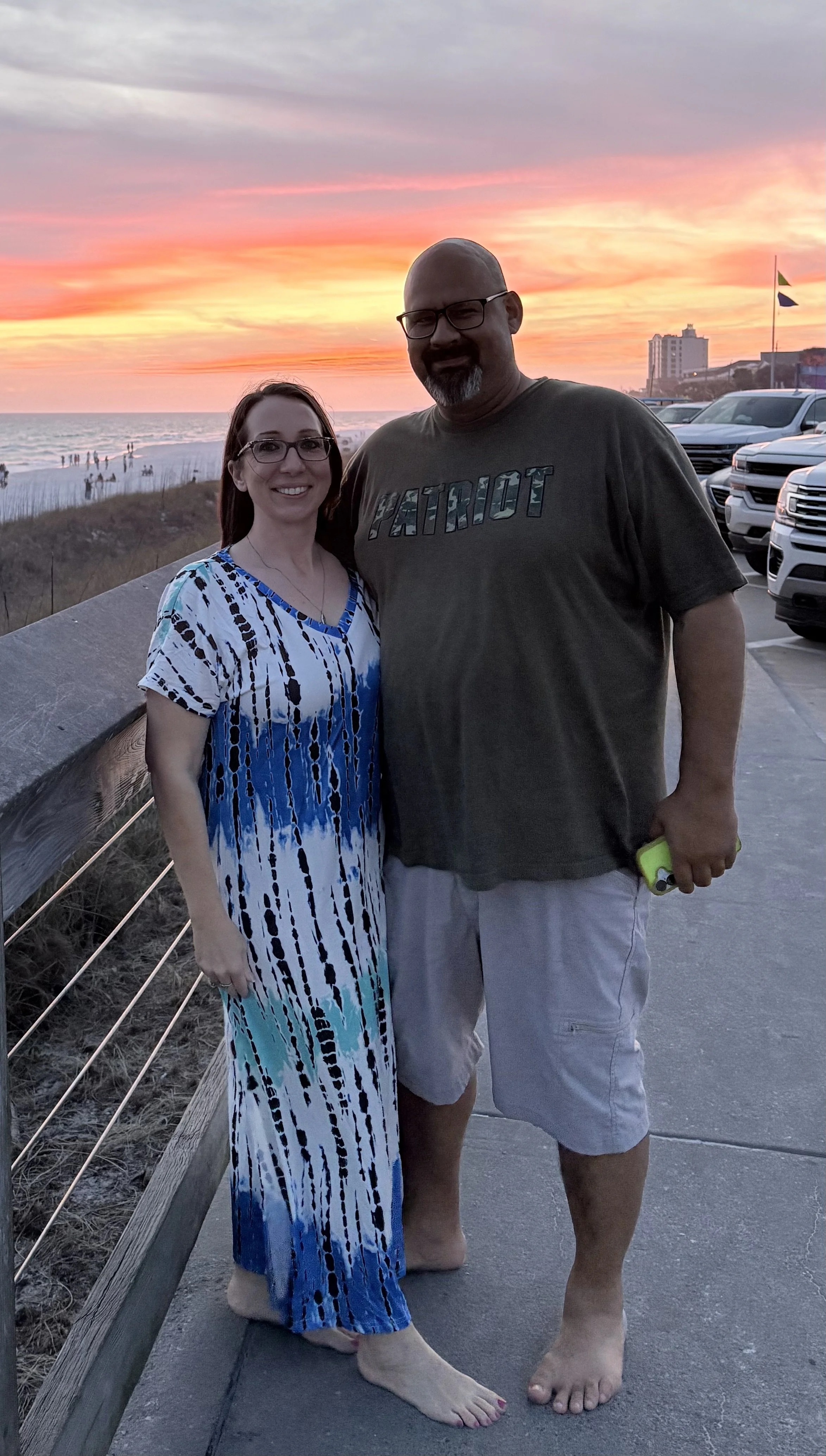 Owners of Emerald Coast Beach Rides & Rentals standing together at sunset in Miramar Beach Florida.