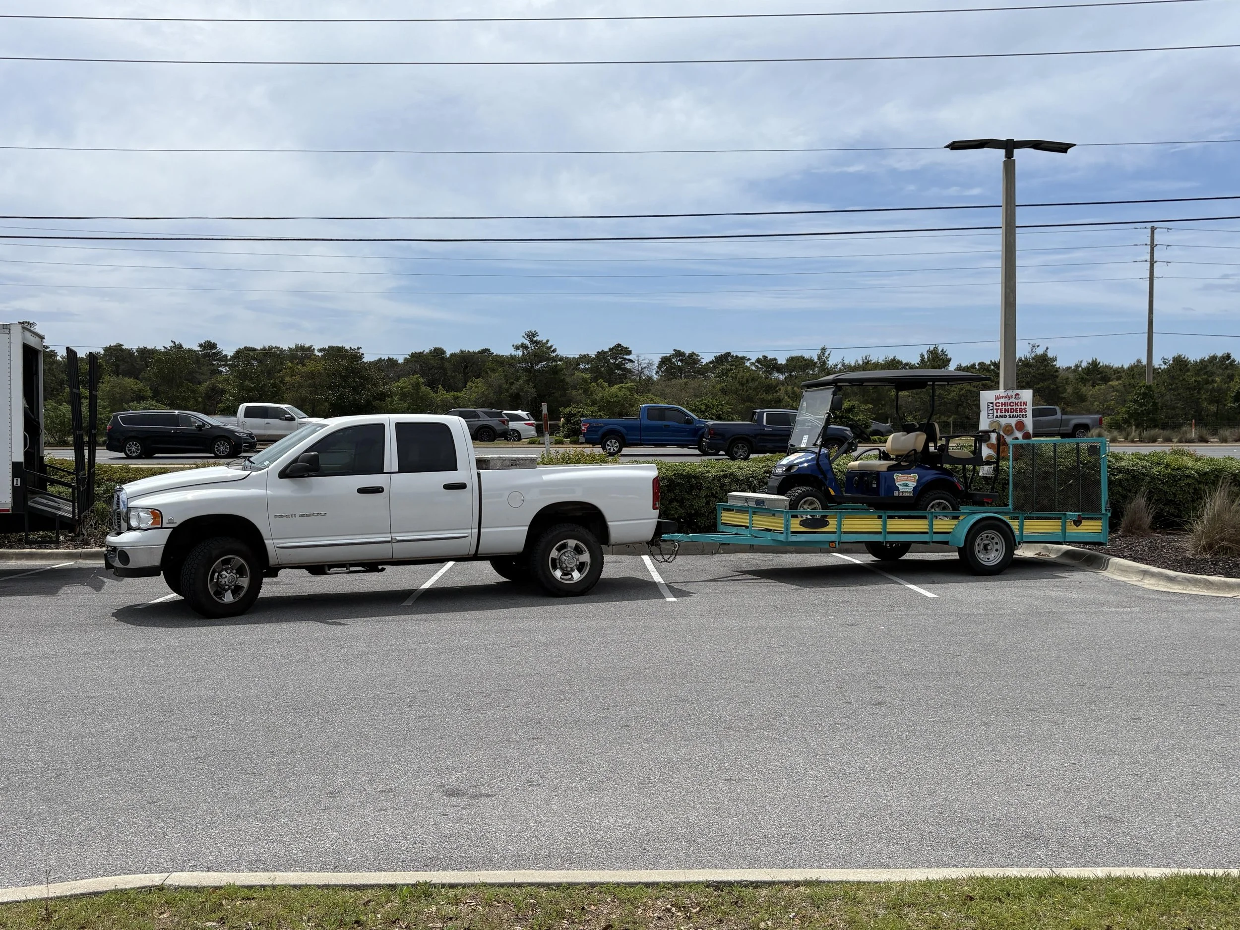 Golf cart rental being delivered on a trailer by Emerald Coast Beach Rides & Rentals in Destin Florida.