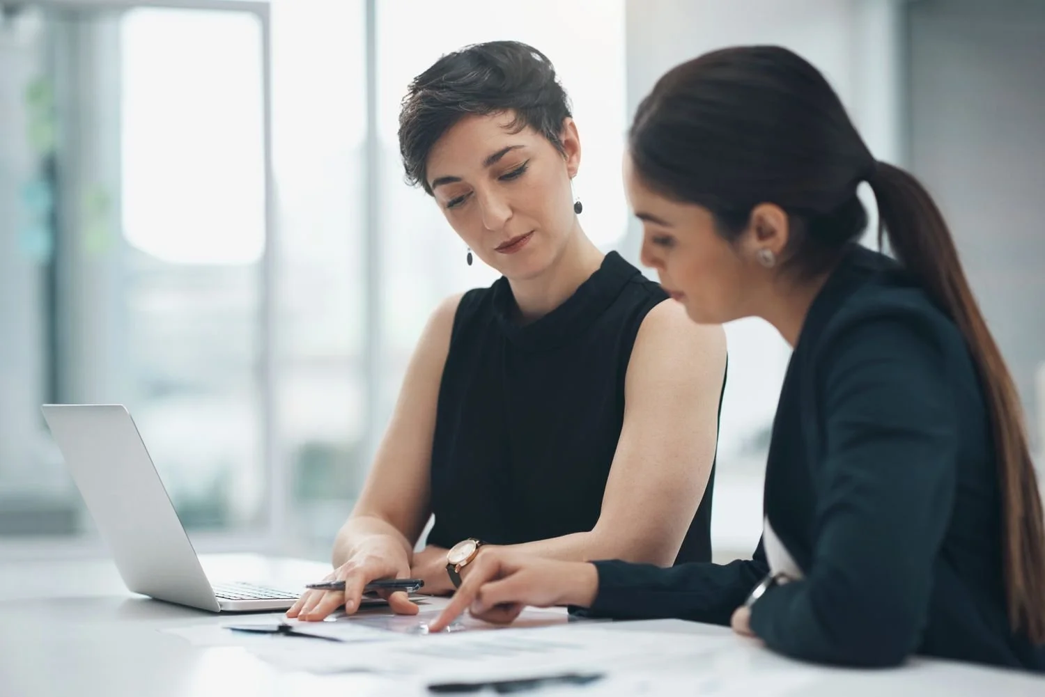 Business professionals reviewing financial documents together during a client meeting
