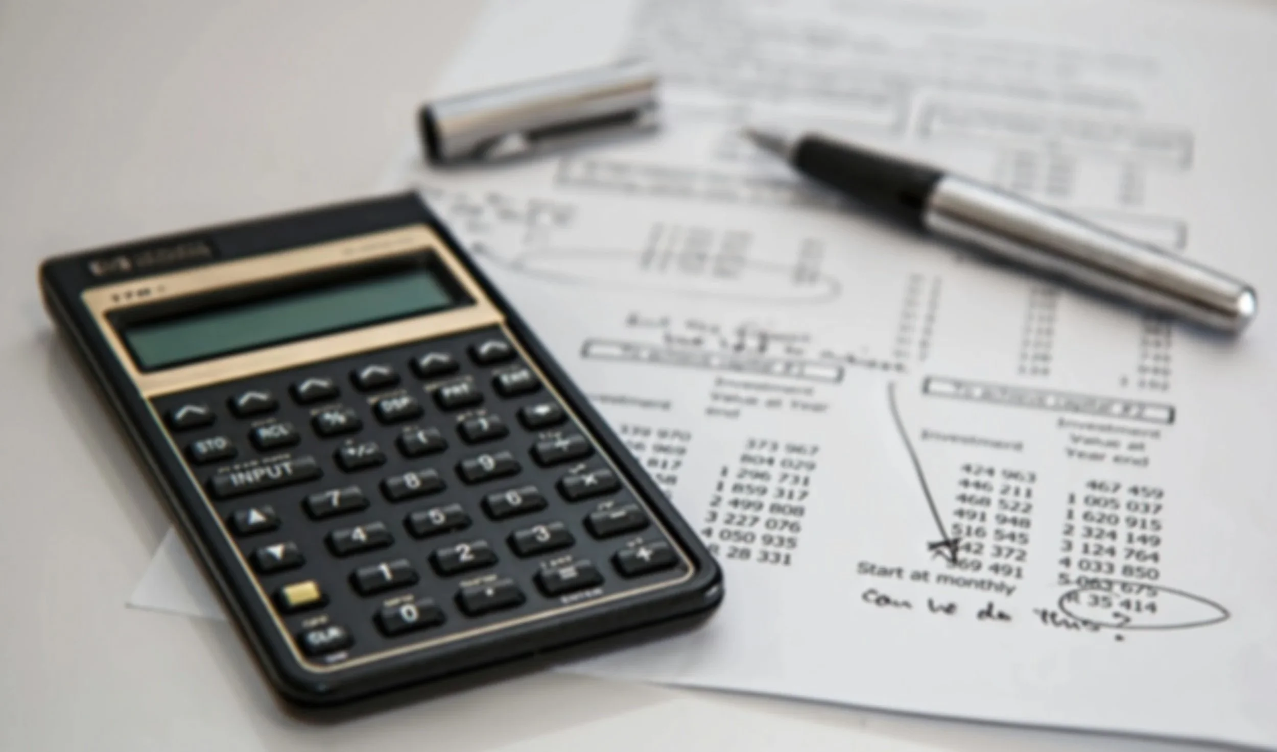 Calculator and financial documents used for bookkeeping, tax, and accounting review