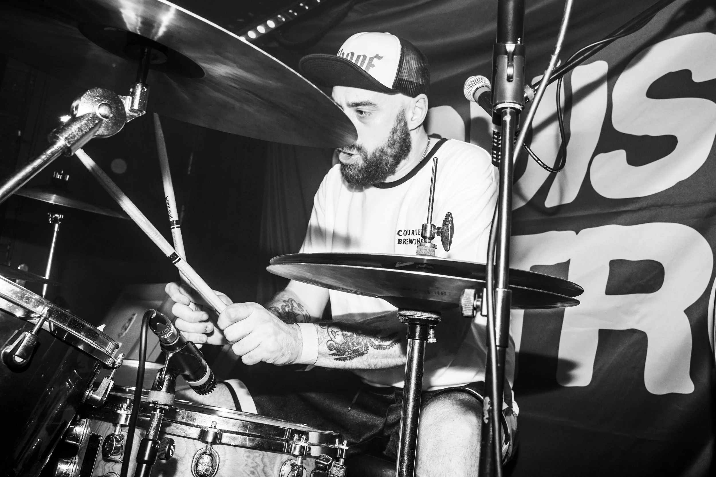 Drummer of punk band, Bruise Control, wearing Courier Brewing merch at a gig in Manchester, UK