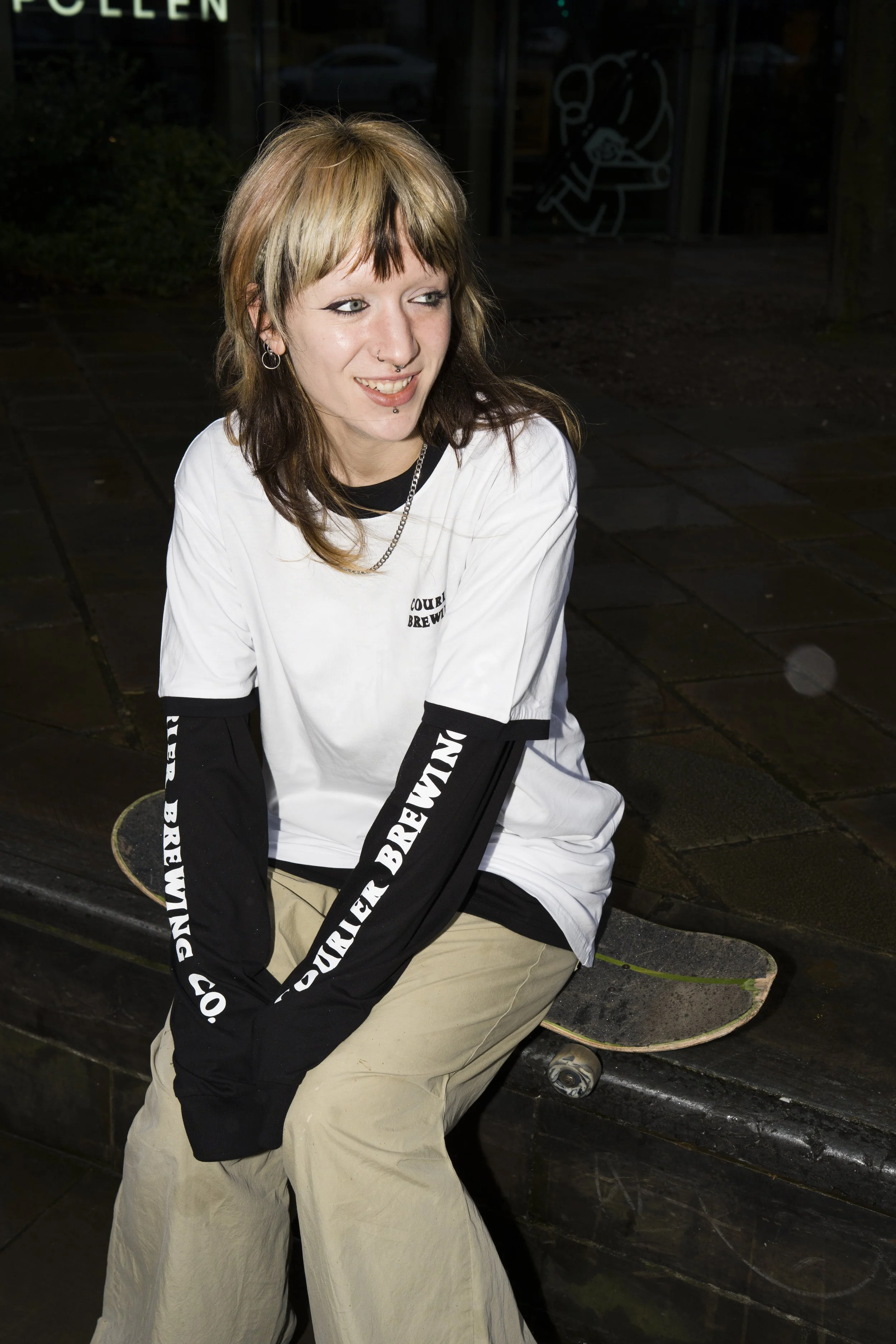 Alice, a skateboarder, wearing a long and short sleeve Courier Brewing Co t-shirt for a merch shoot in Manchester, UK