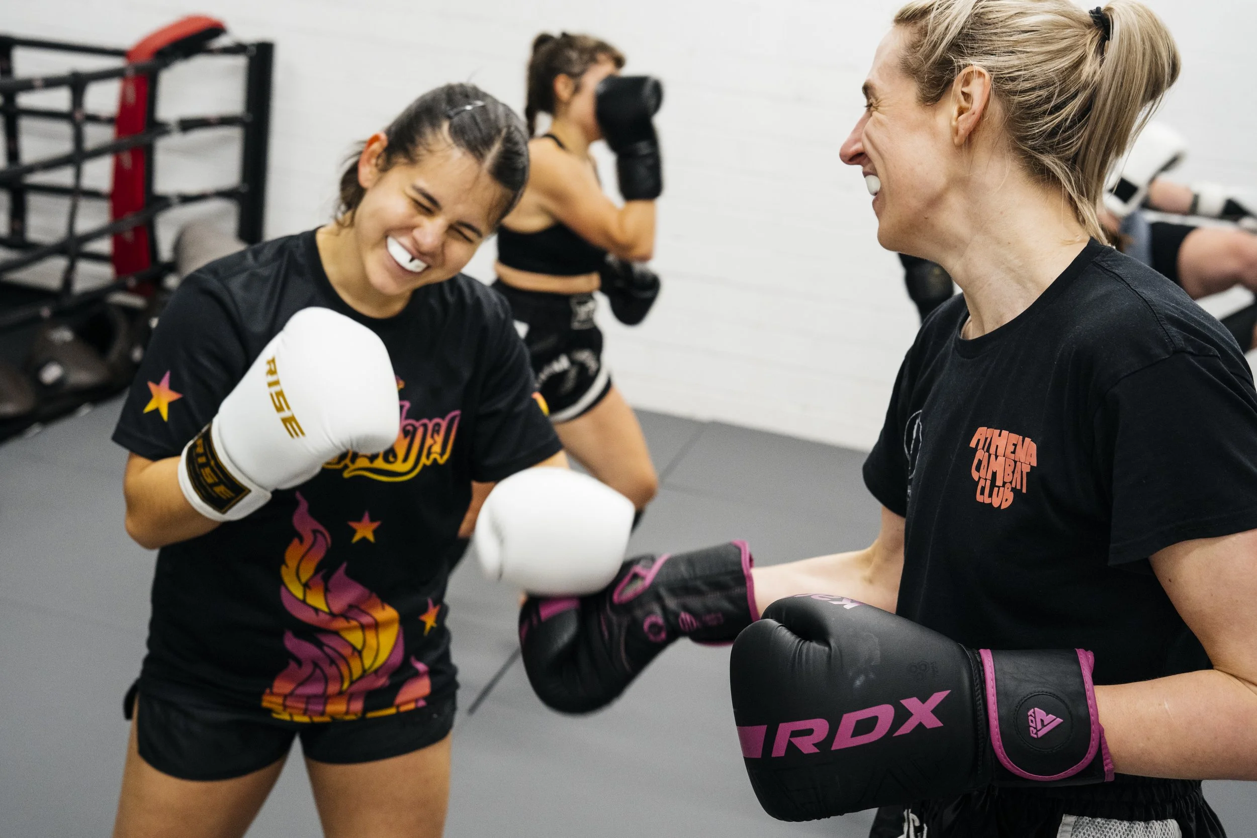 Fighters laughing during sparring at Athena Combat Club Fighter's Class
