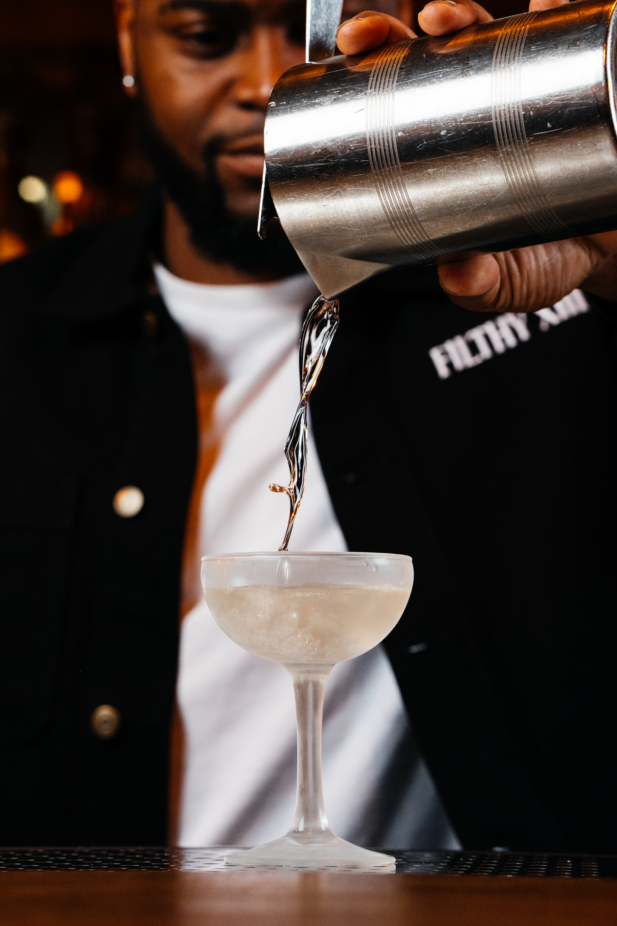 Bartender pouring a Martini cocktail at Filthy XIII, Bristol