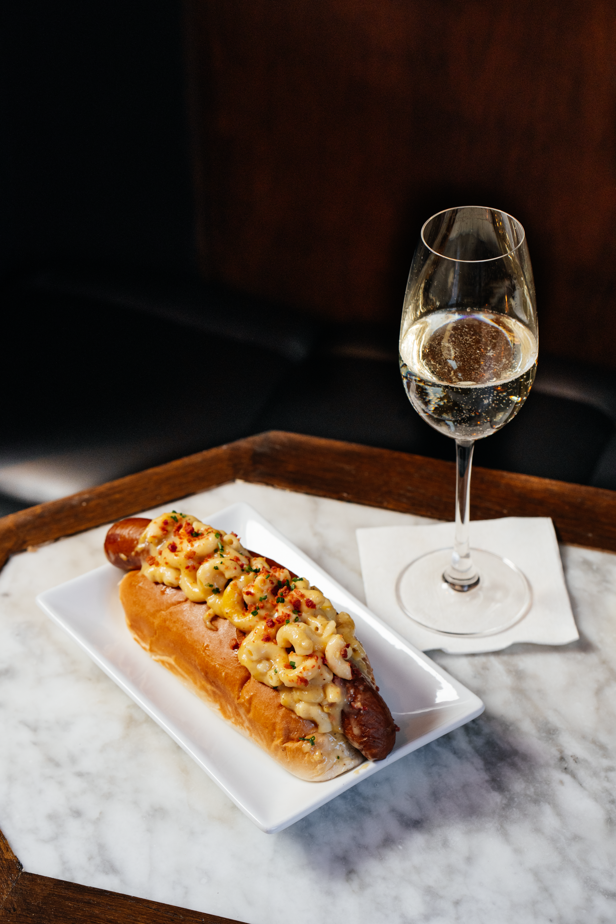 Prosecco and a hotdog on a table at Filthy XIII, Bristol