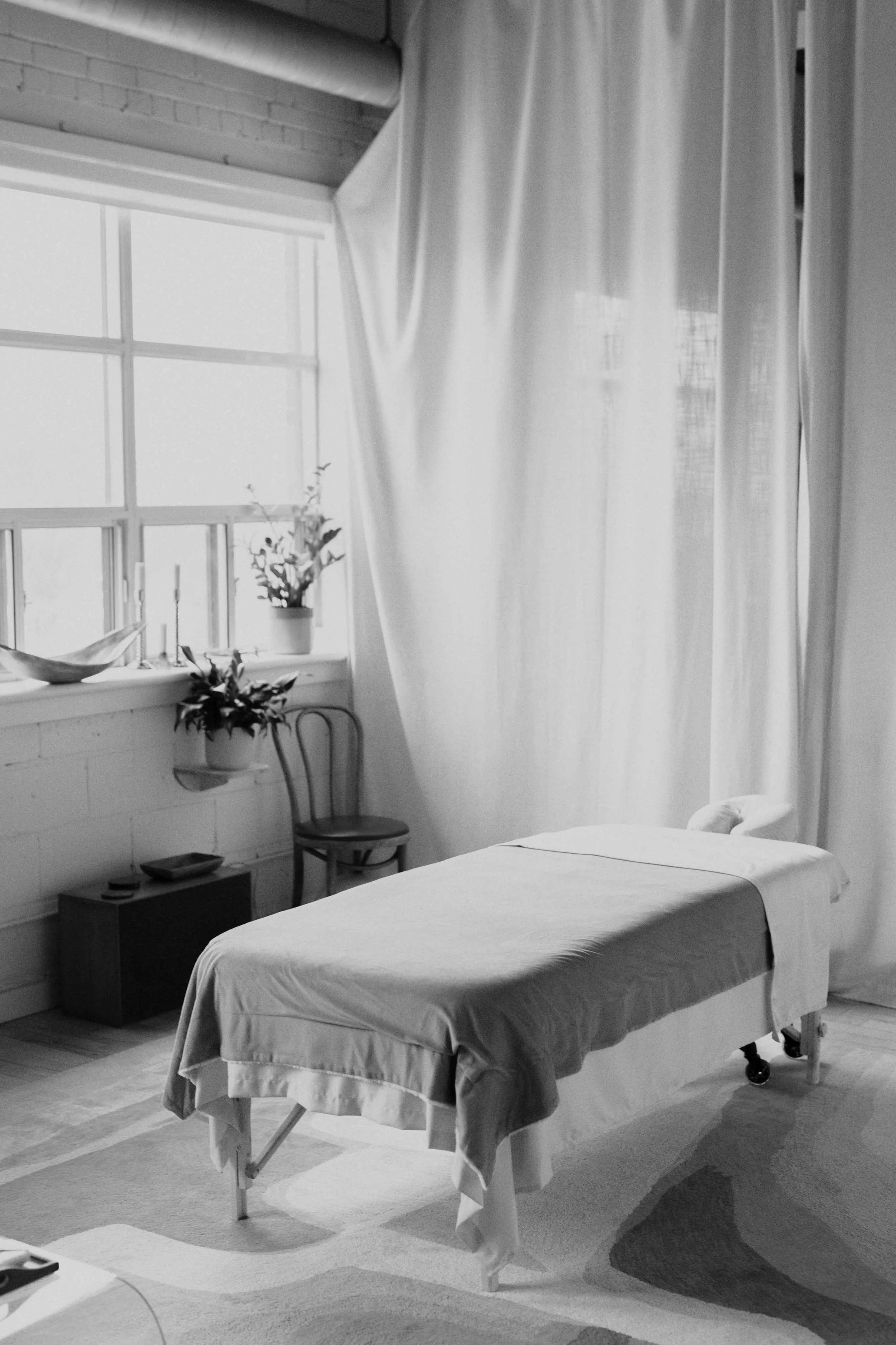 black and white photo of a massage table in the inter•being bodywork downtown toronto massage therapy studio-bordered