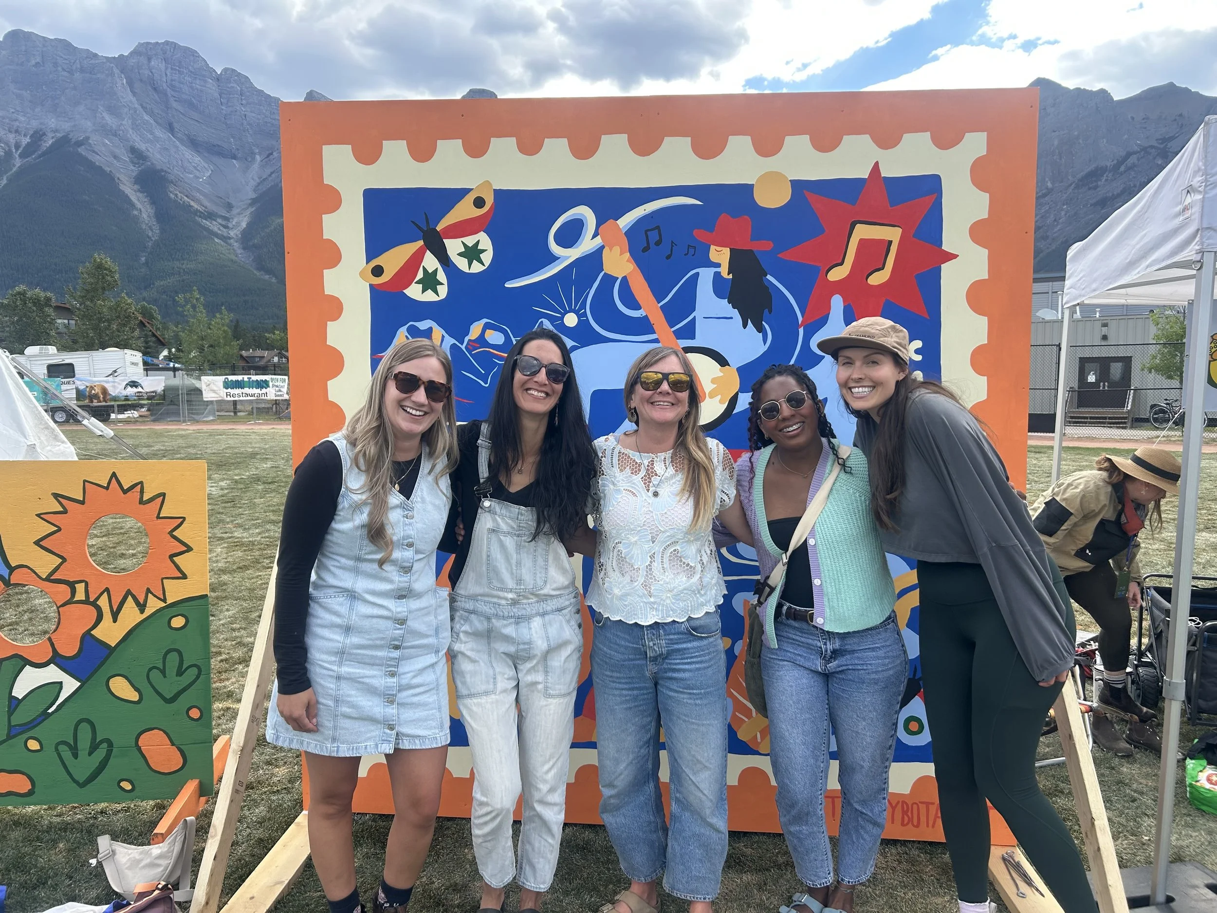 Friends posing in front of the Out of Office mural