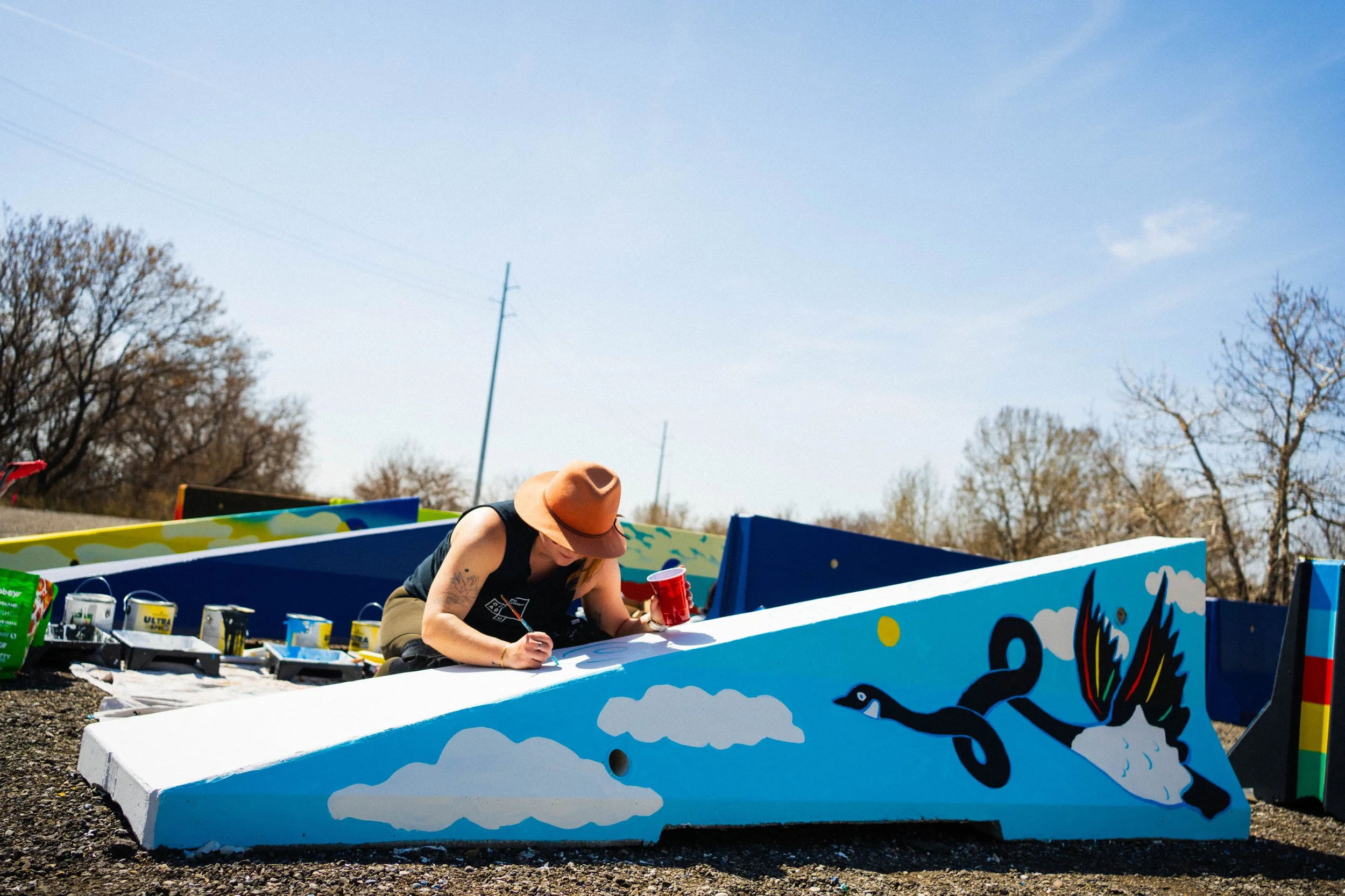Teenybotanist painting jersey barriers for BUMP Mural Festival