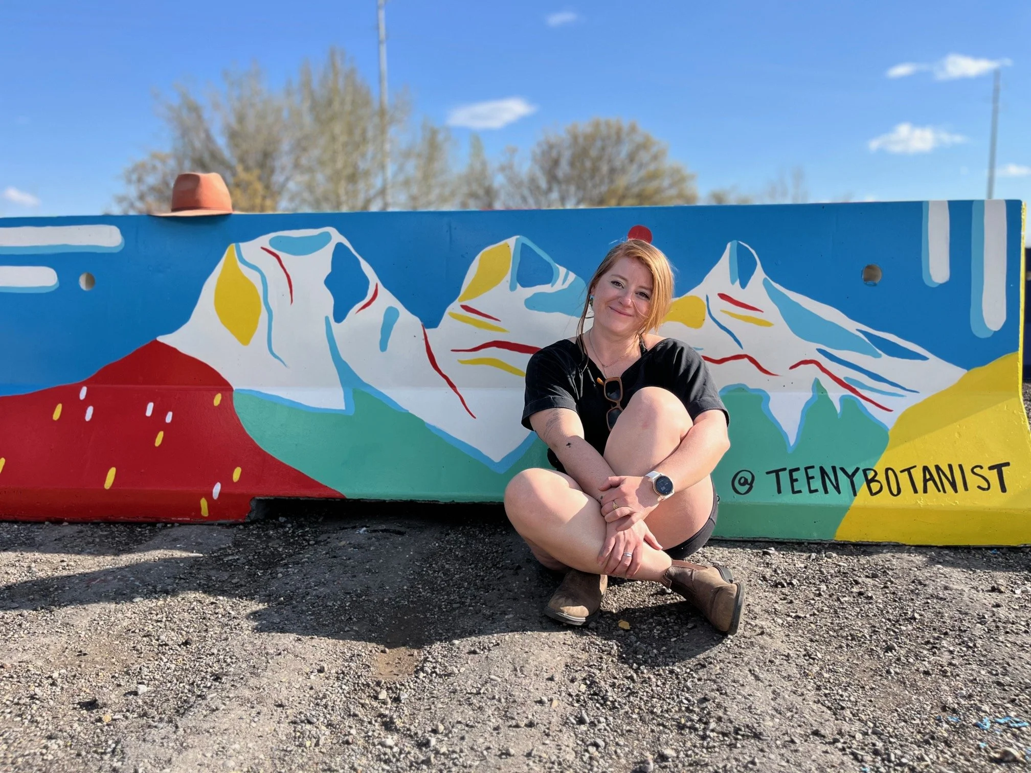 Cecelia Leddy of Teenybotanist sitting in front of her painted mountain jersey barrier mural