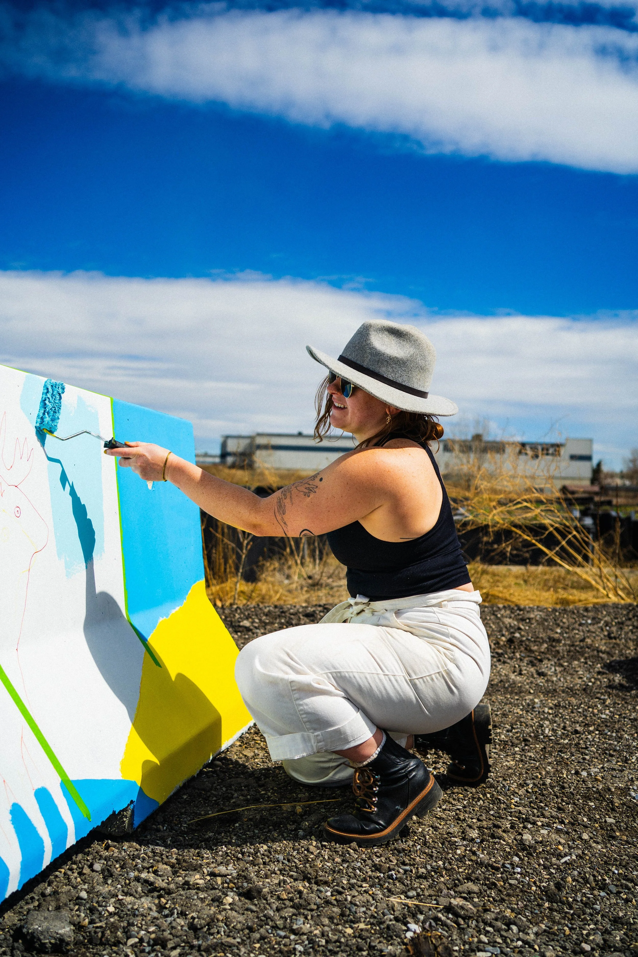 Teenybotanist painting a jersey barrier mural for BUMP Road Works