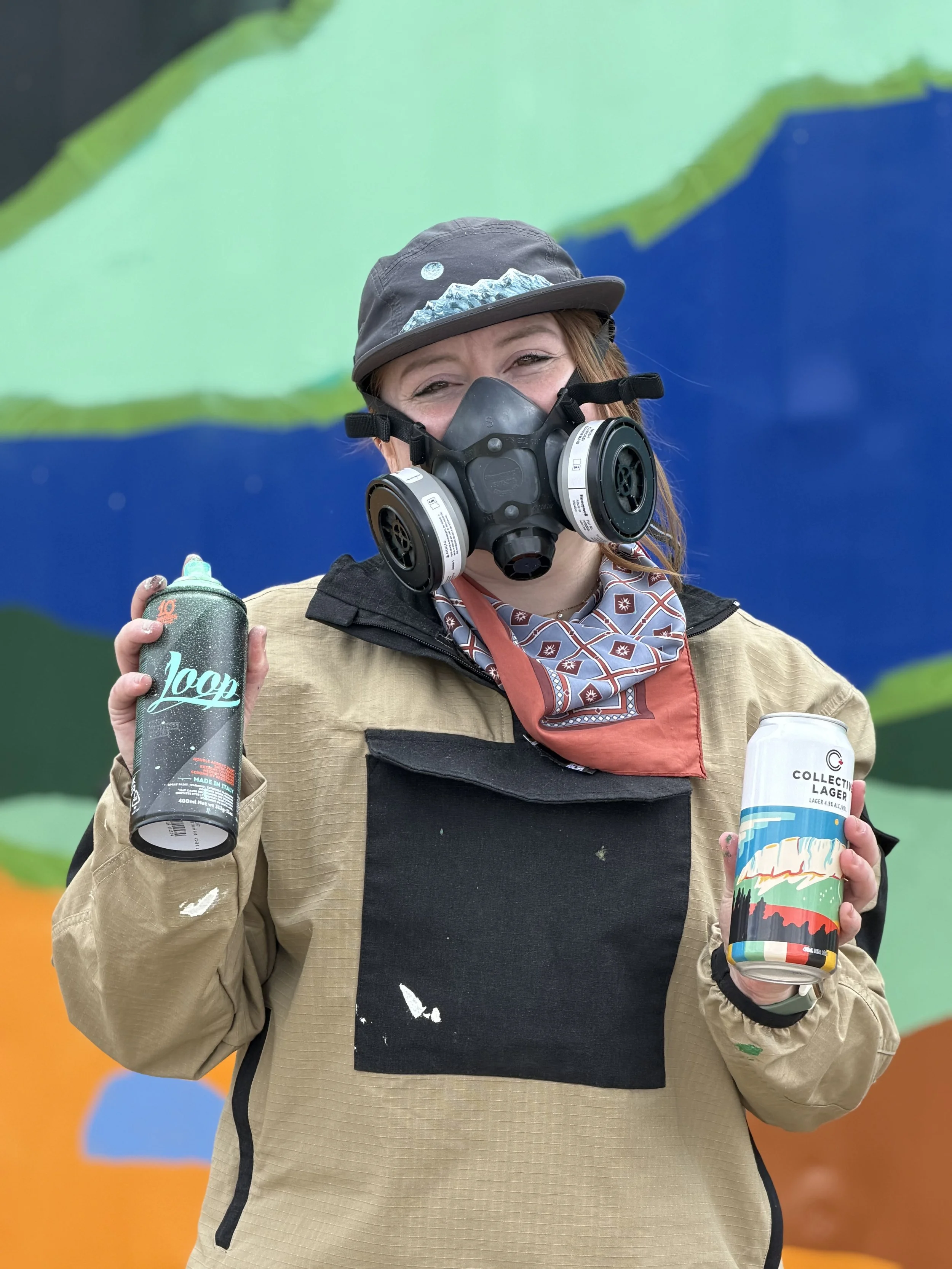 Teenybotanist in a respirator holding spray paint at the Jasper mural