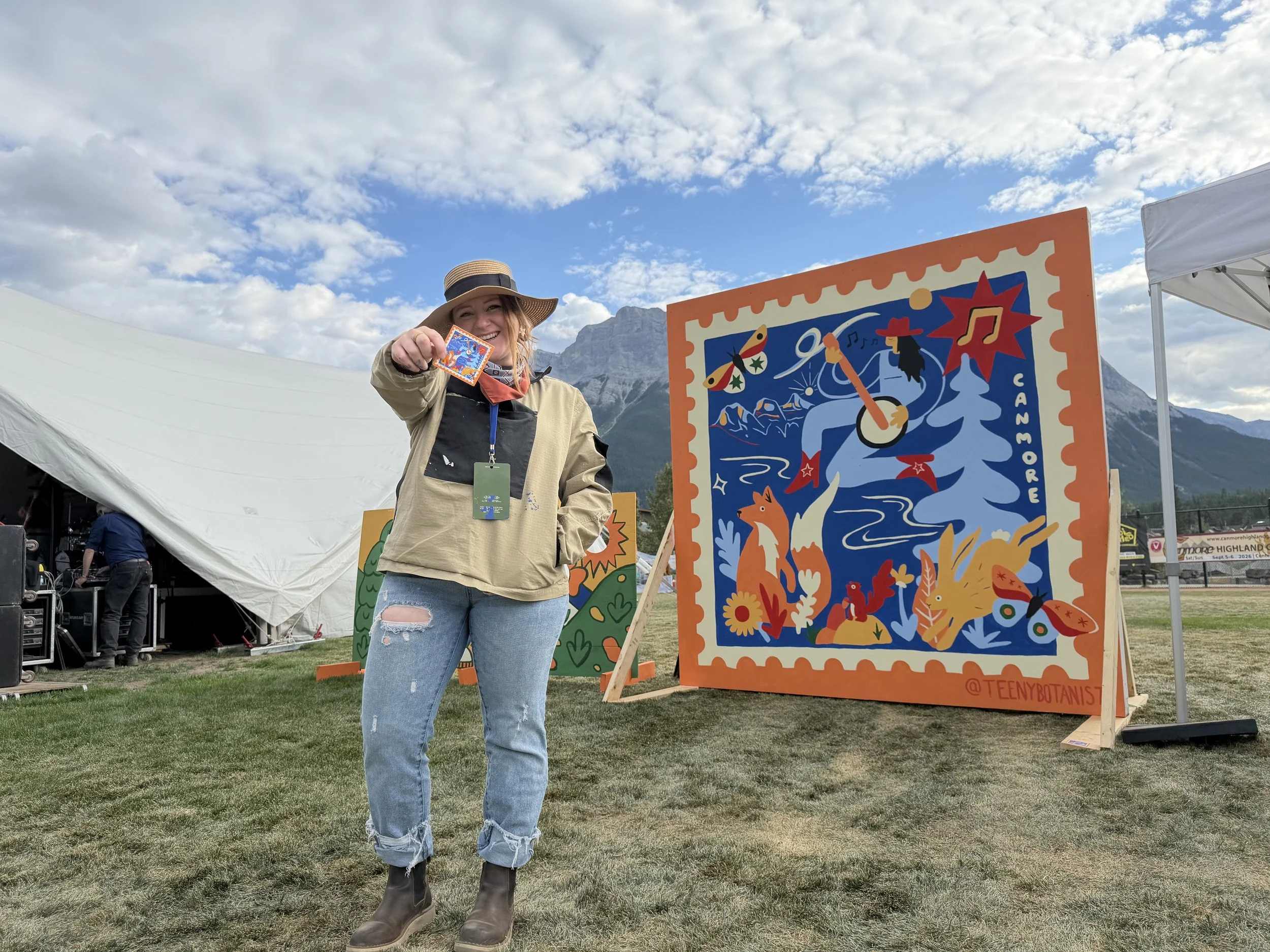 Teenybotanist beside her live-painted mural at Canmore Folk Festival