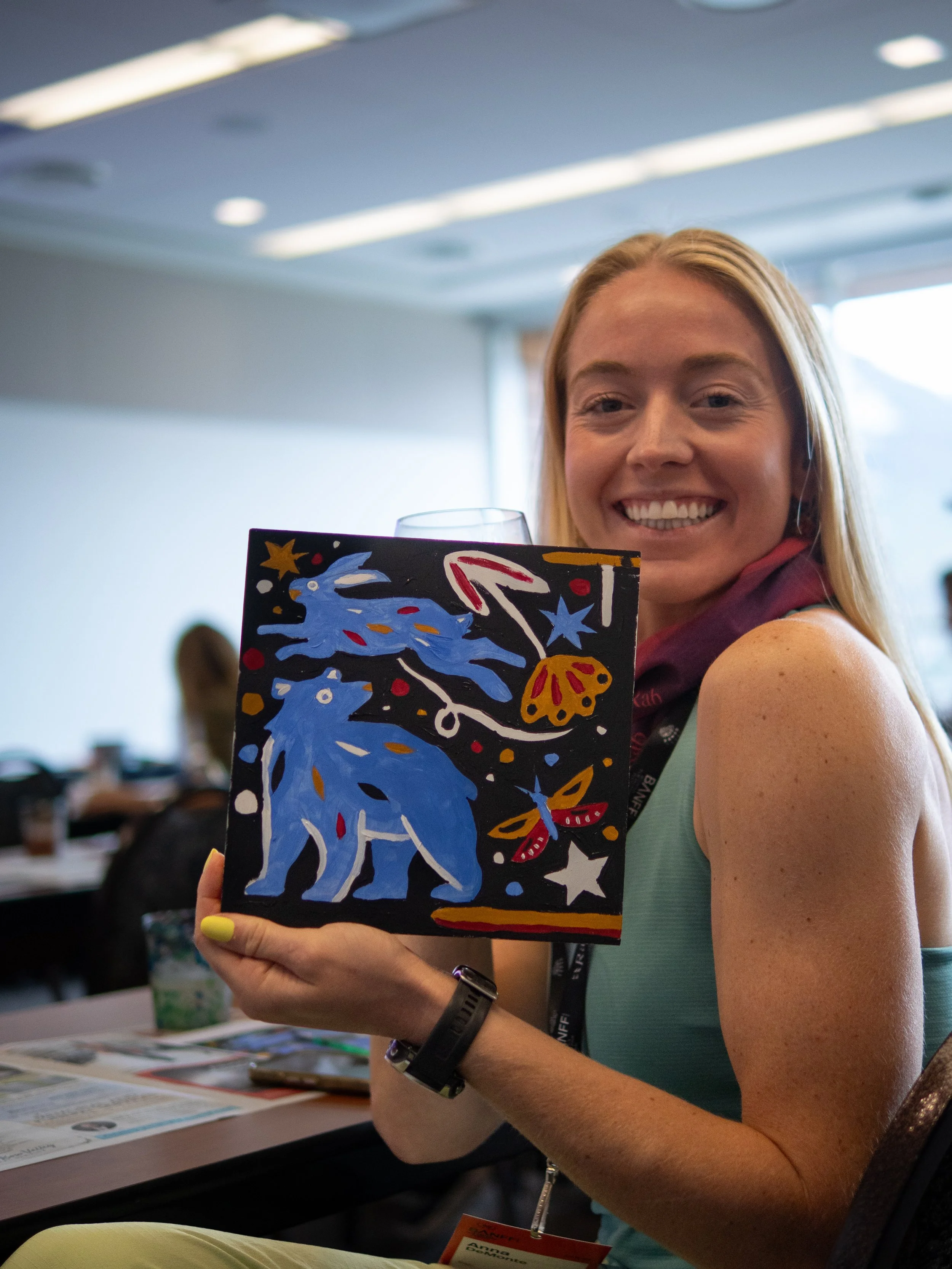 Workshop participant holding her finished painting