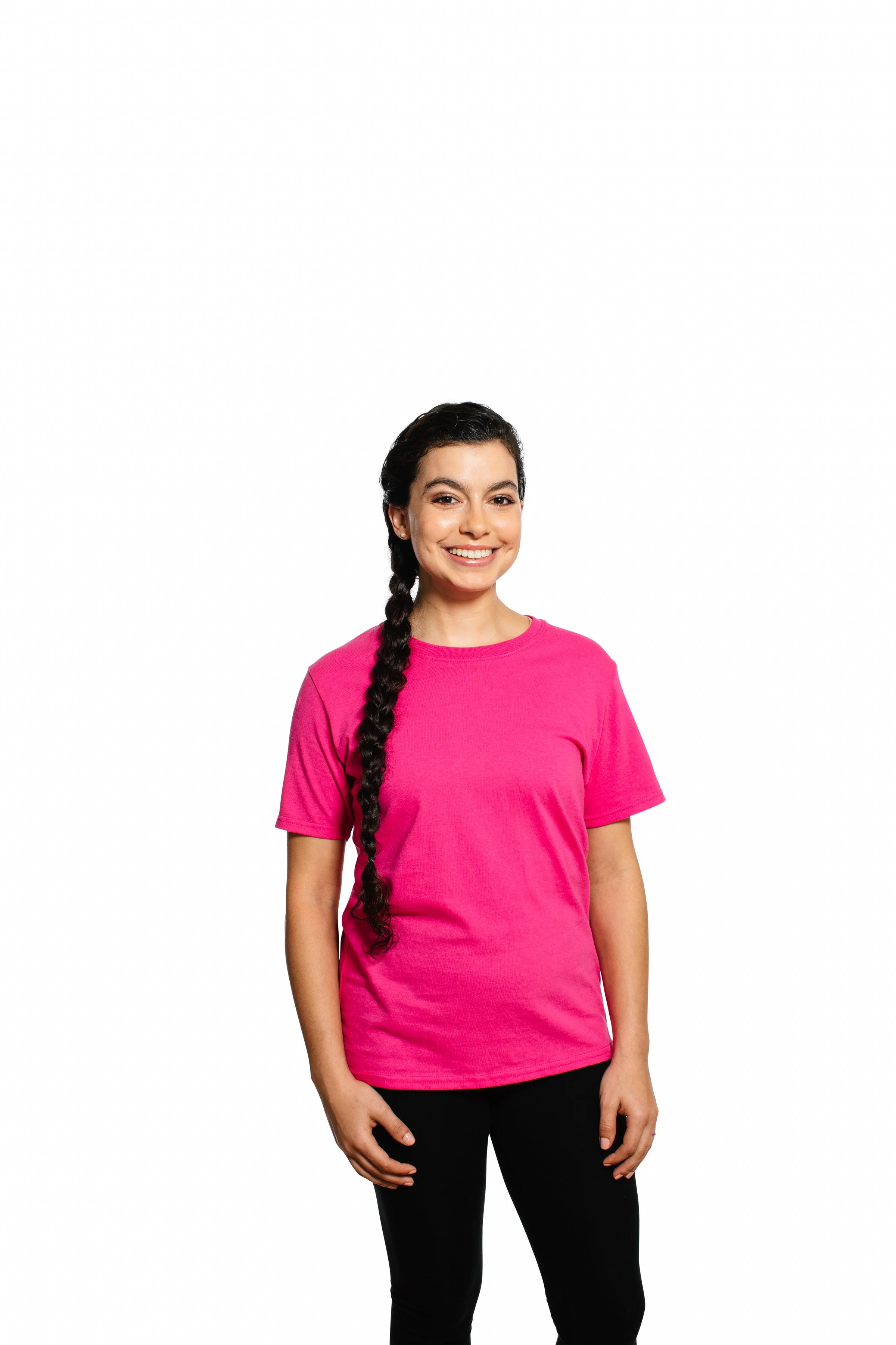 A young woman with long dark hair in a braid, wearing a bright pink t-shirt and black pants, smiling against a plain white background.