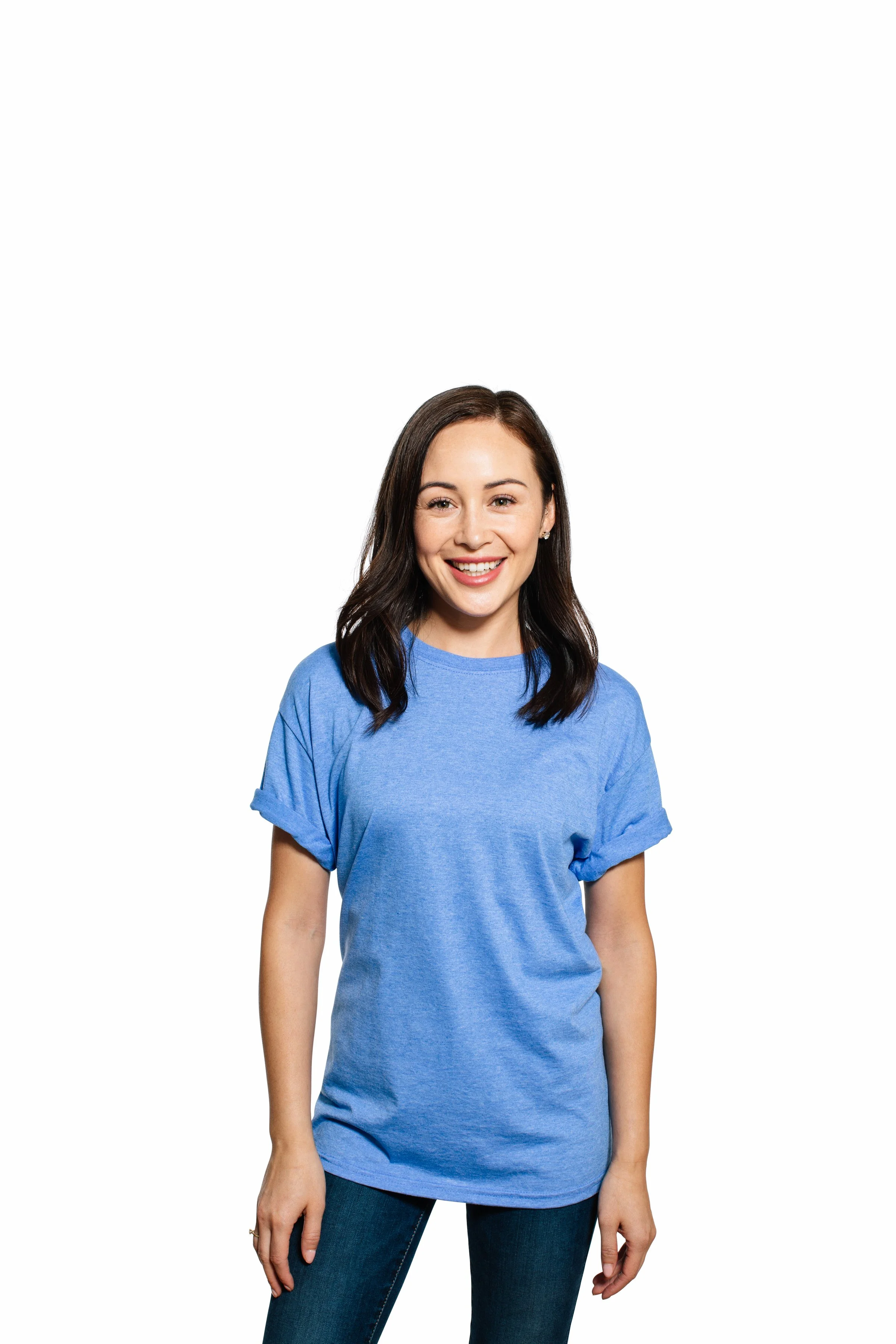 A young woman with shoulder-length dark hair wearing a blue T-shirt, smiling, standing against a white background.