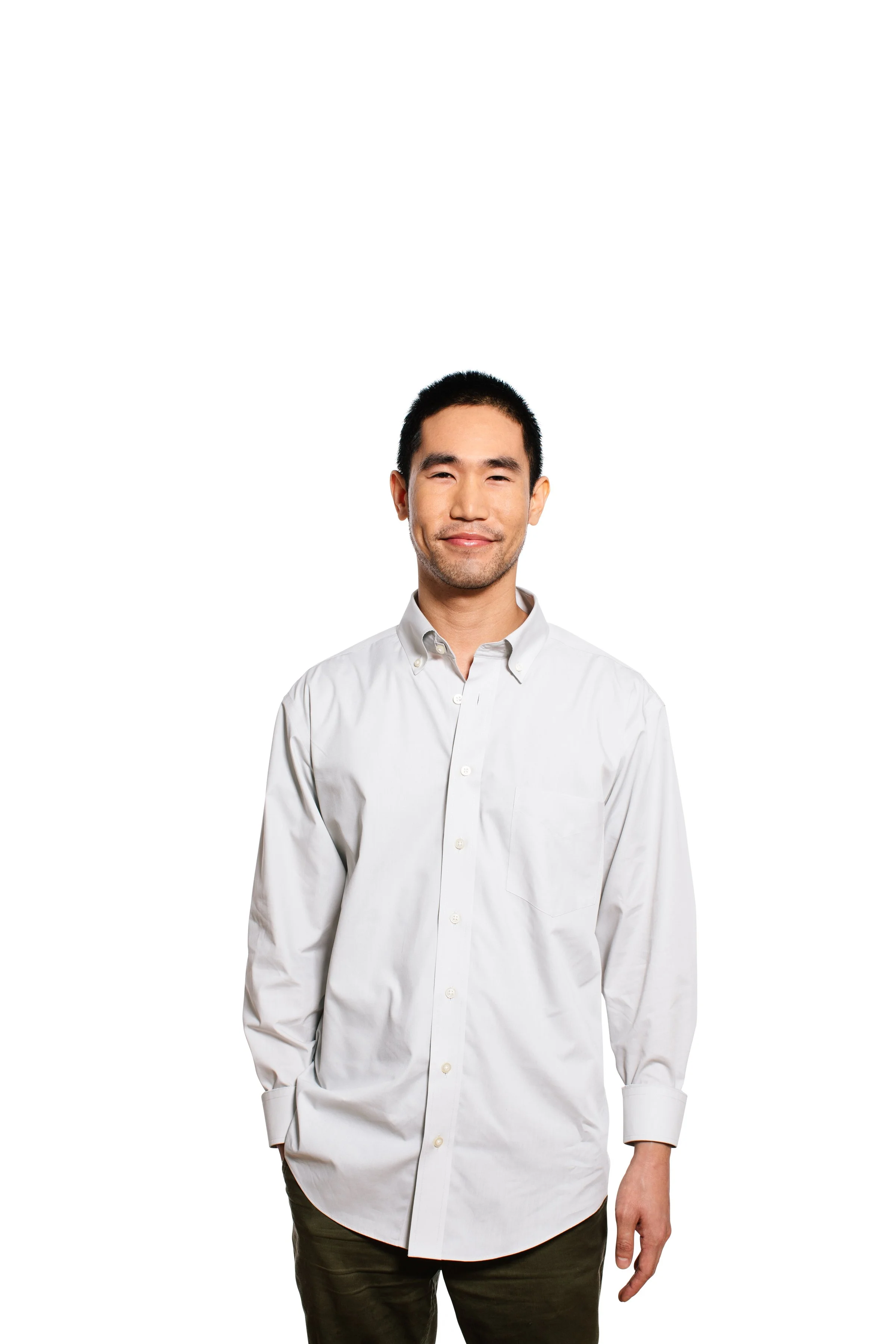Portrait of a smiling Asian man in a white button-up shirt and dark pants, standing against a plain white background.