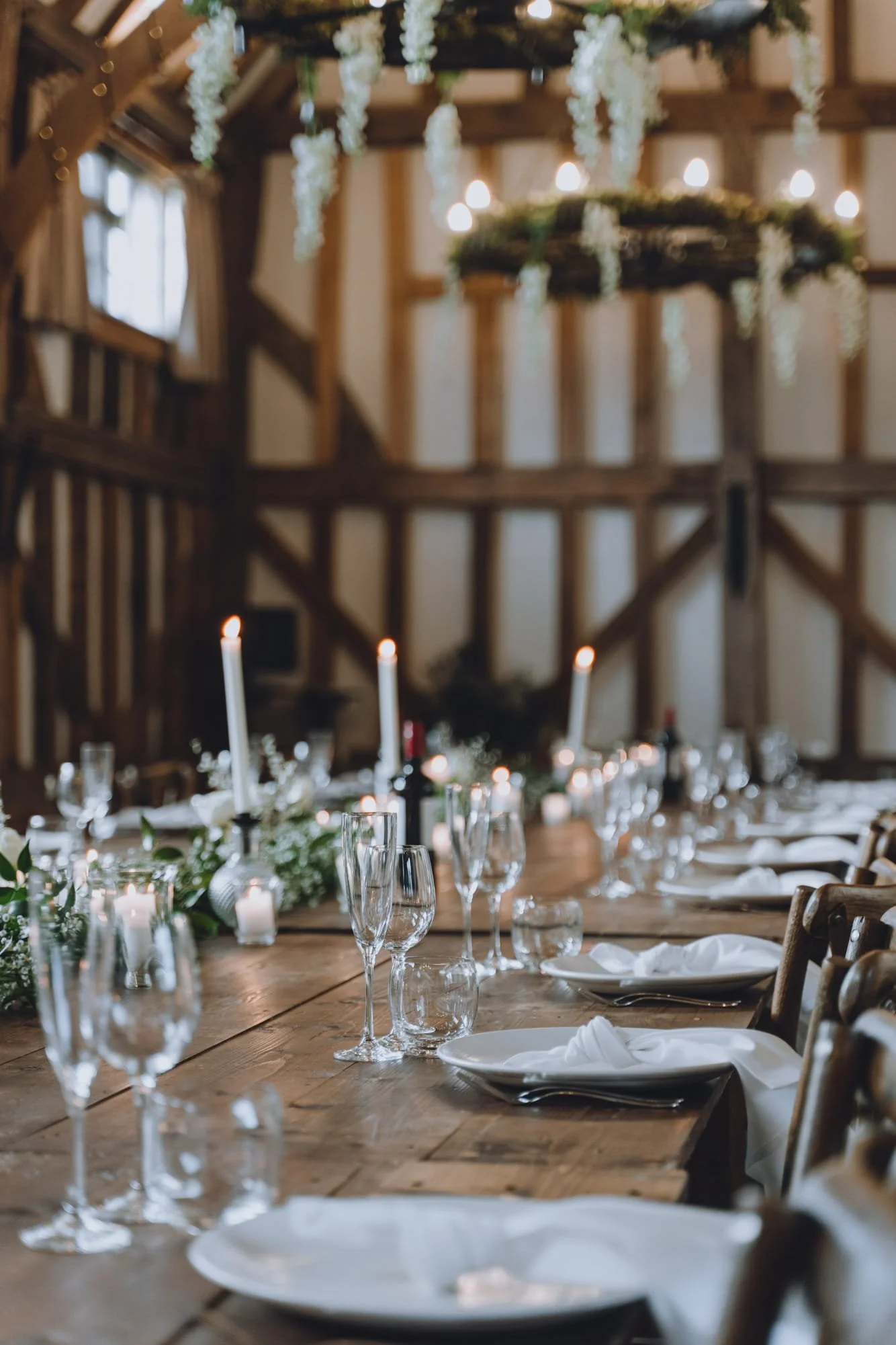 Long table setting with linen napkins, candles and glassware