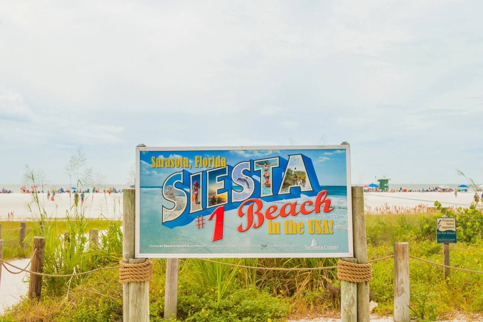 Sign indicating Sarasota, Florida's Siesta Beach as the #1 beach in the USA with a beach scene in the background.
