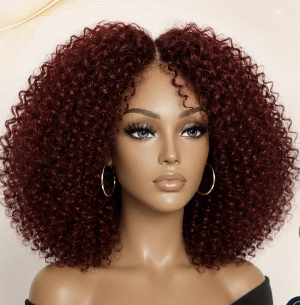 Woman with voluminous, curly, red oily raw human hair medical wig and hoop earrings, wearing makeup with natural lips and eye makeup.