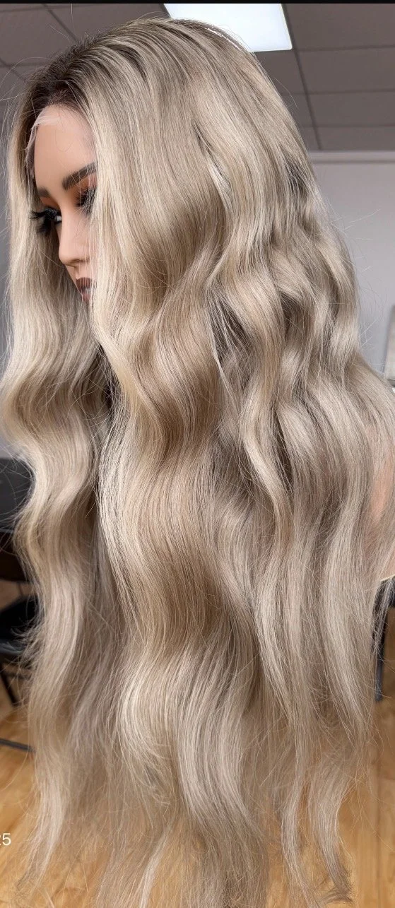 A woman with long, wavy, platinum blonde ombre medical wig.