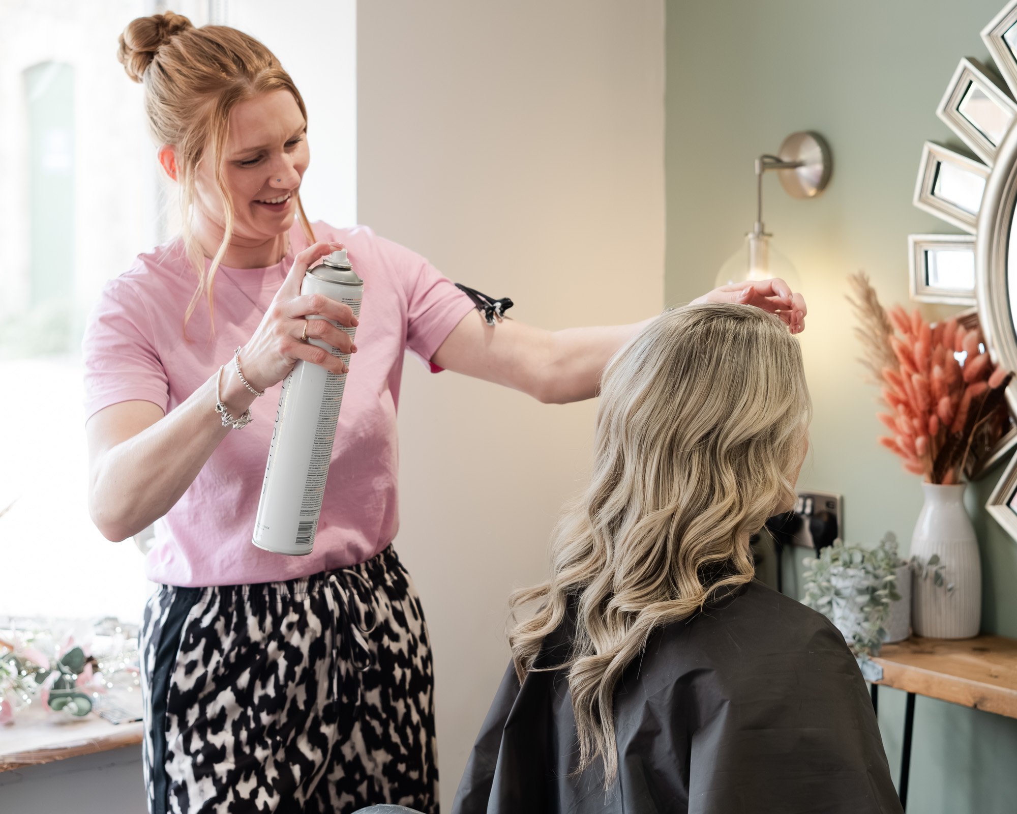 An action shot of Casey styling a client's hair at Hair at Suite 7