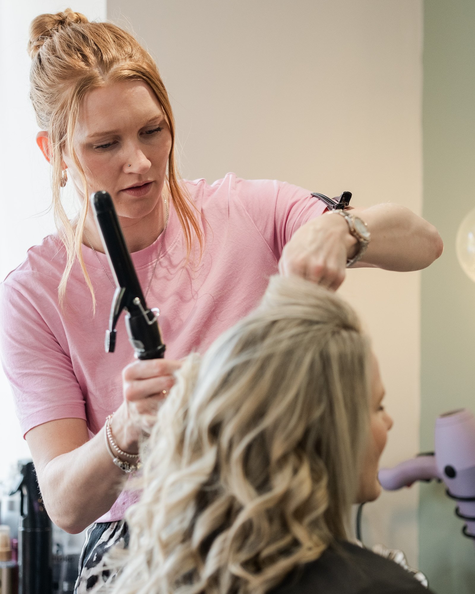 An action shot of Casey cutting a client's hair at Hair at Suite 7
