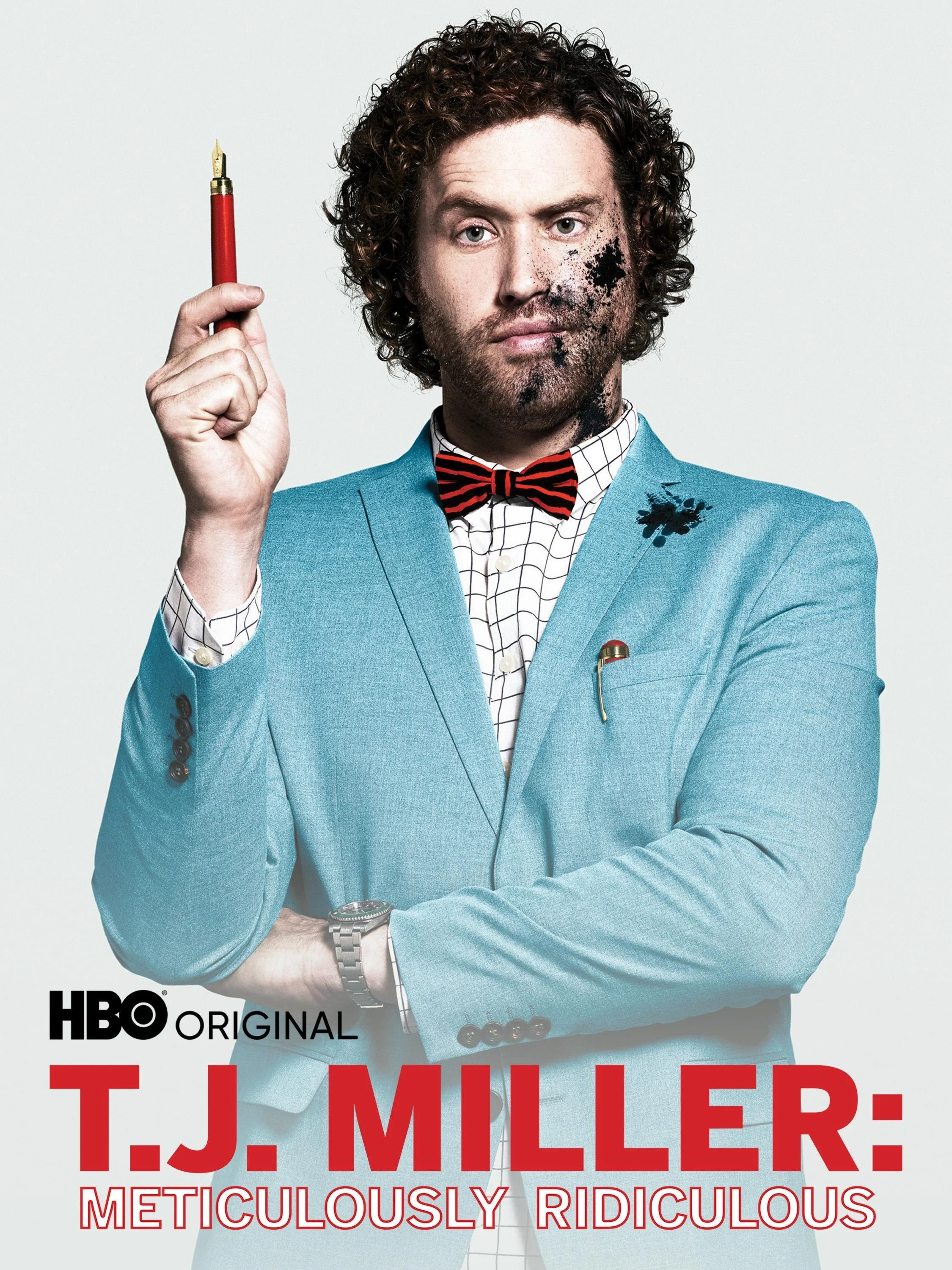 Poster for the HBO original series "T.J. Miller: Meticulously Ridiculous" featuring comedian T.J. Miller wearing a blue suit jacket and red bow tie, holding a red pen in his right hand with a serious expression and ink splatters on his face and suit.