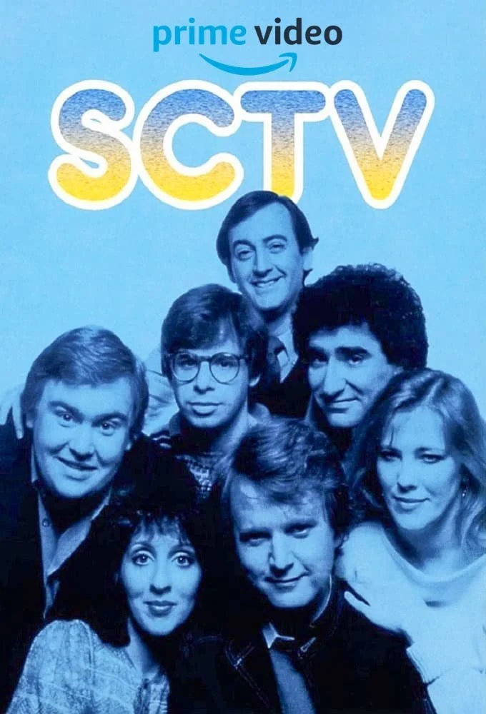 Black-and-white photo of the cast of SCTV - John Candy, Joe Flaherty, Rick Moranis, Catherine O'Hara, Eugene Levy, Dave Thomas, and Andrea Martin - with the words 'Prime Video' and 'SCTV' displayed above them.