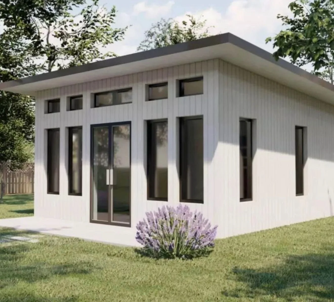Modern white house with large windows, surrounded by green lawn and trees, with purple flowers in front.